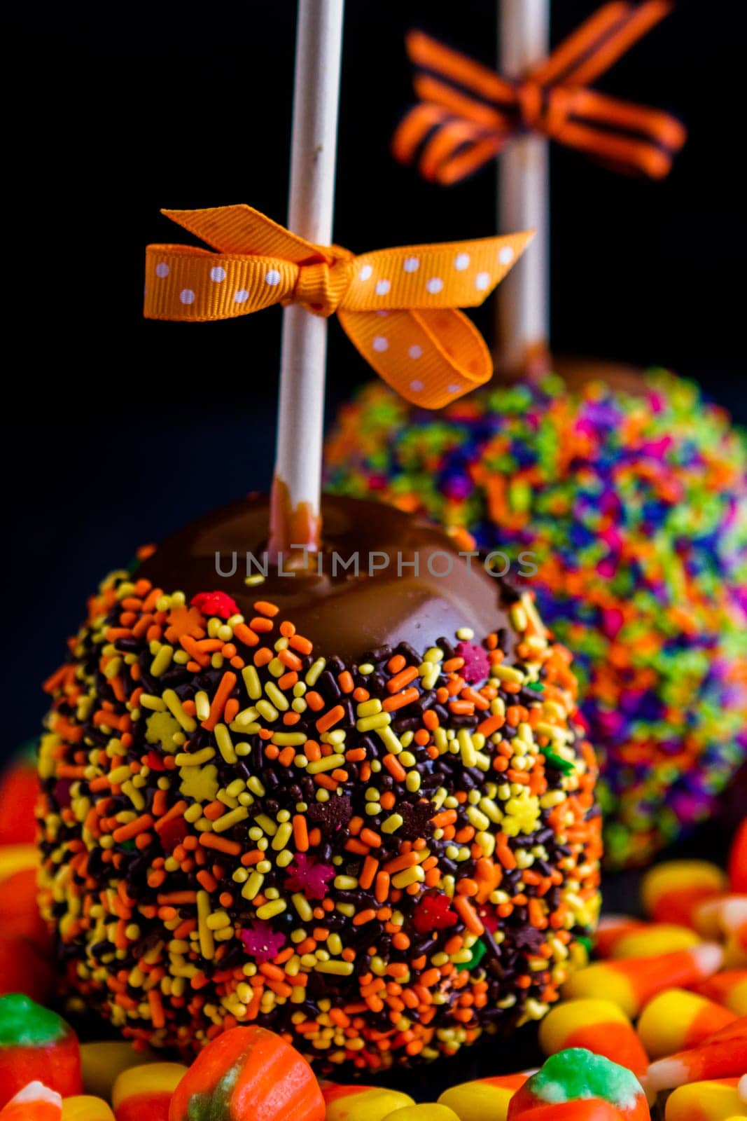 Hand dipped caramel apple covered with multi color sprinkles.