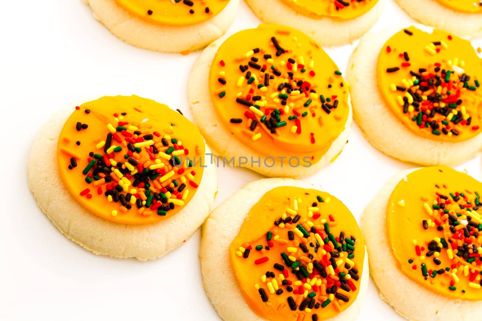 Sugar cookies with orange icing and spkinkles.