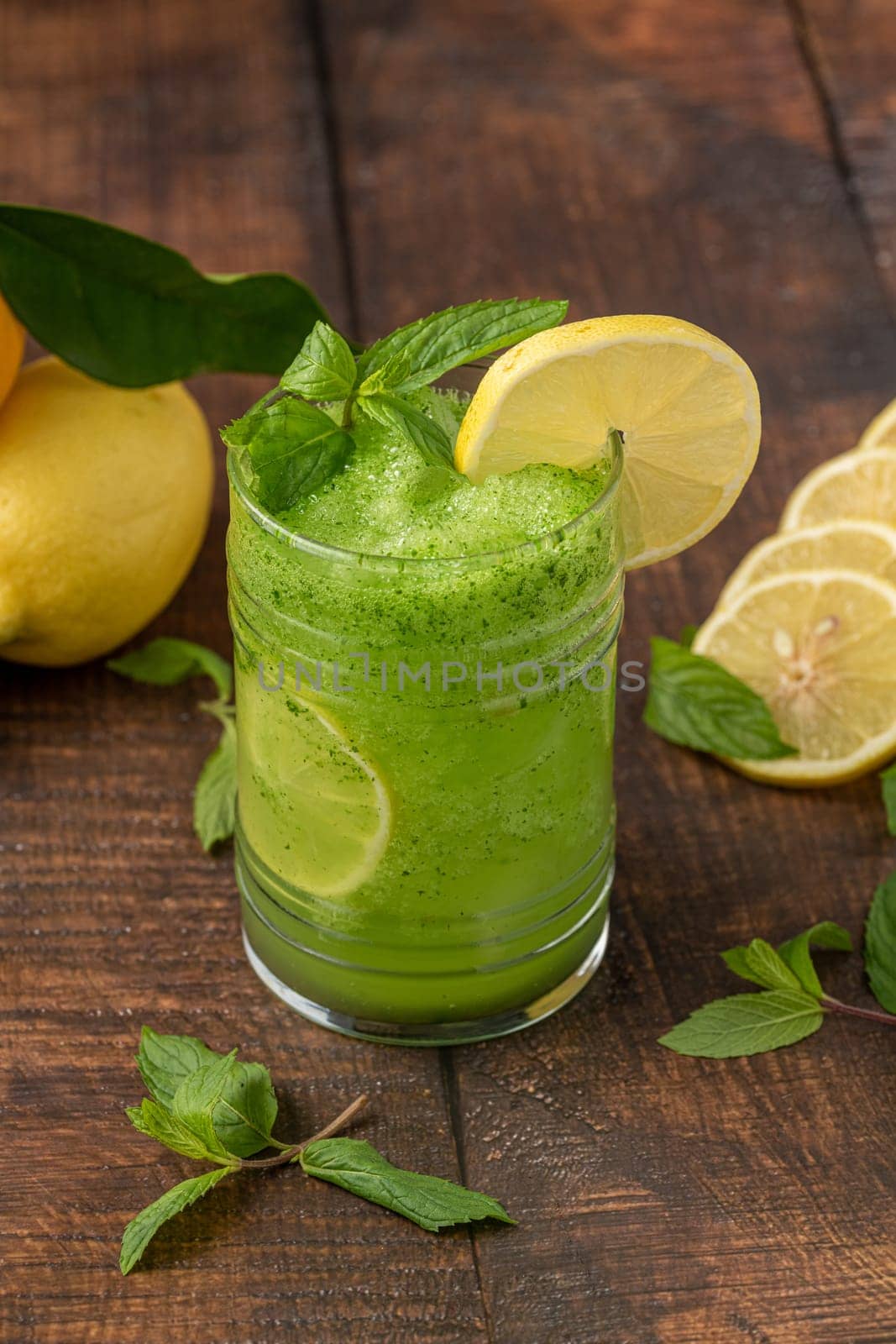 Lemonade with ice and mint in glass glass on wooden table