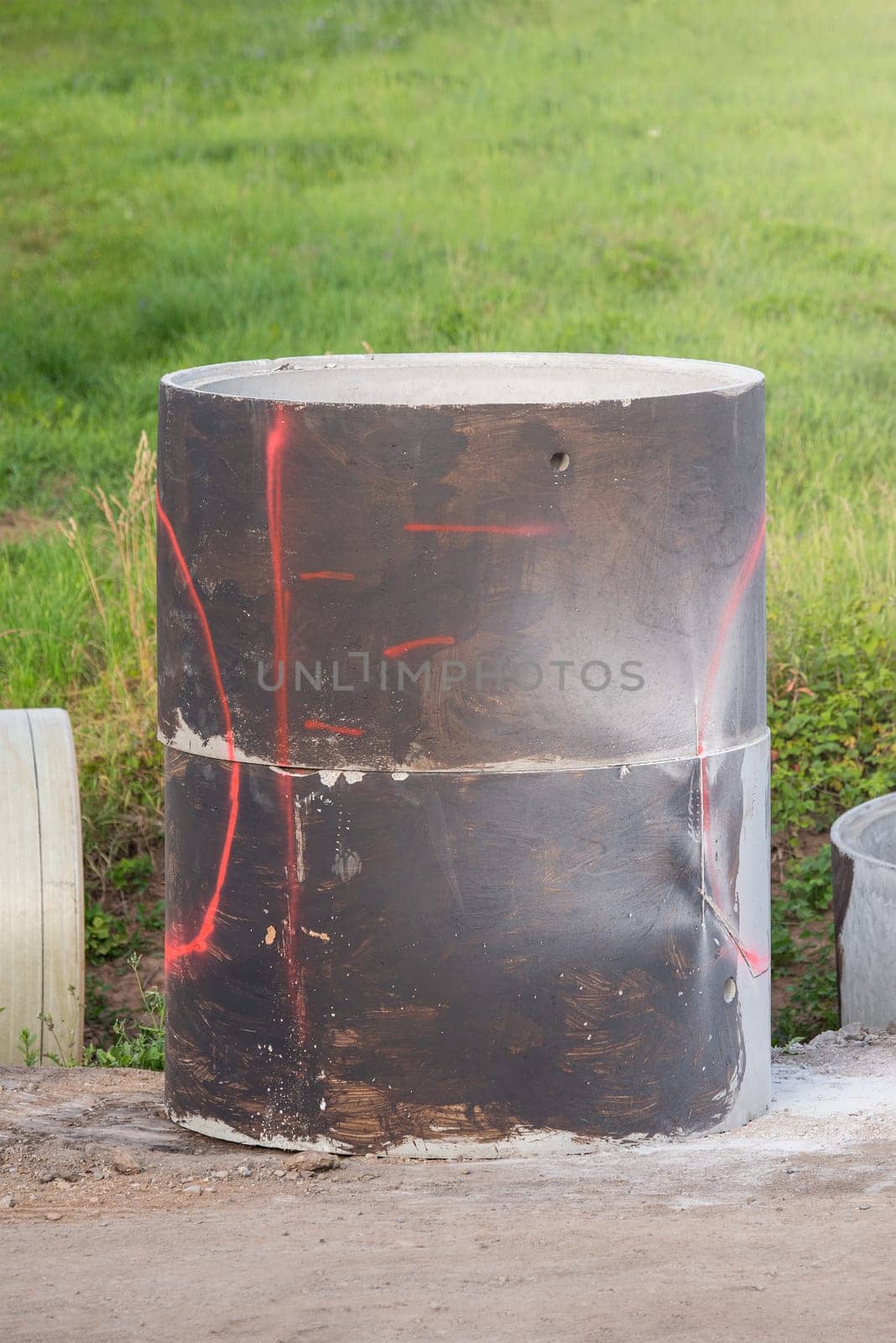 Concrete pipes on the side of the reconstructed road. Large concrete rings to collect wastewater. Reconstruction of the rainwater collection system in the city. High quality photo