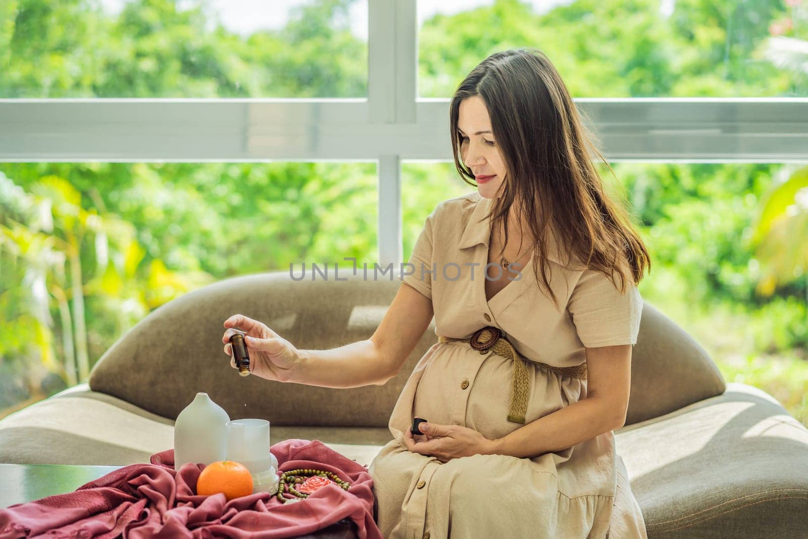 A serene moment captured as a pregnant woman after 40 embraces the soothing benefits of aroma oils and an aroma diffuser, enhancing her pregnancy journey with relaxation and tranquility.