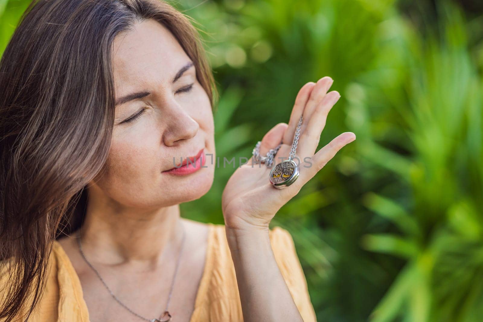 pregnant woman after 40 demonstrating the use of an aroma pendant, combining style and aromatherapy during her pregnancy journey.