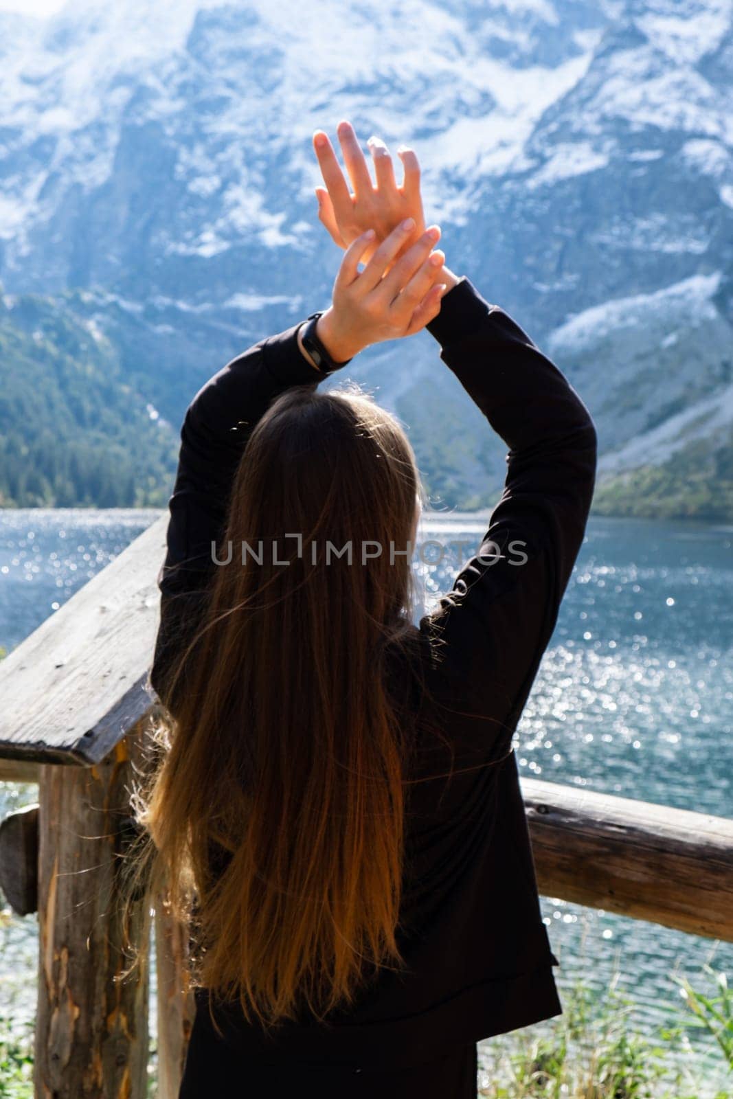 Young woman enjoying nature in Morskie Oko Snowy Mountain Hut in Polish Tatry mountains Zakopane Poland. Naturecore aesthetic beautiful green hills. Mental and physical wellbeing Travel outdoors tourist destination