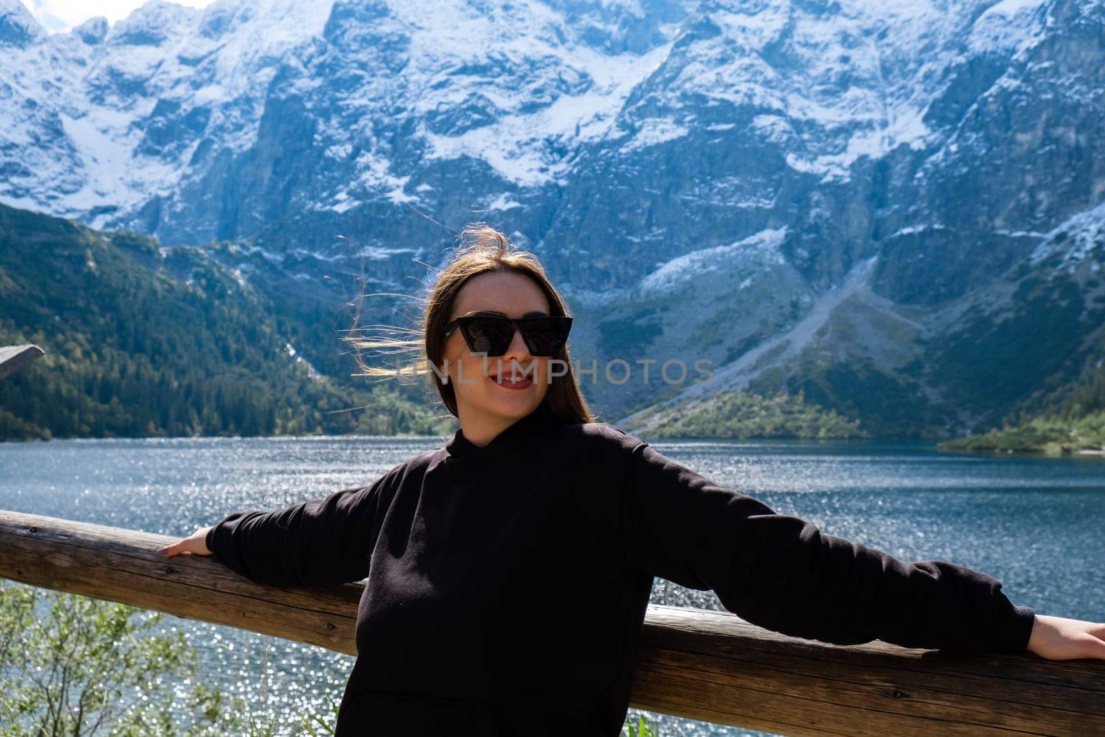 Young woman enjoying nature in Morskie Oko Snowy Mountain Hut in Polish Tatry mountains Zakopane Poland. Naturecore aesthetic beautiful green hills. Mental and physical wellbeing Travel outdoors tourist destination