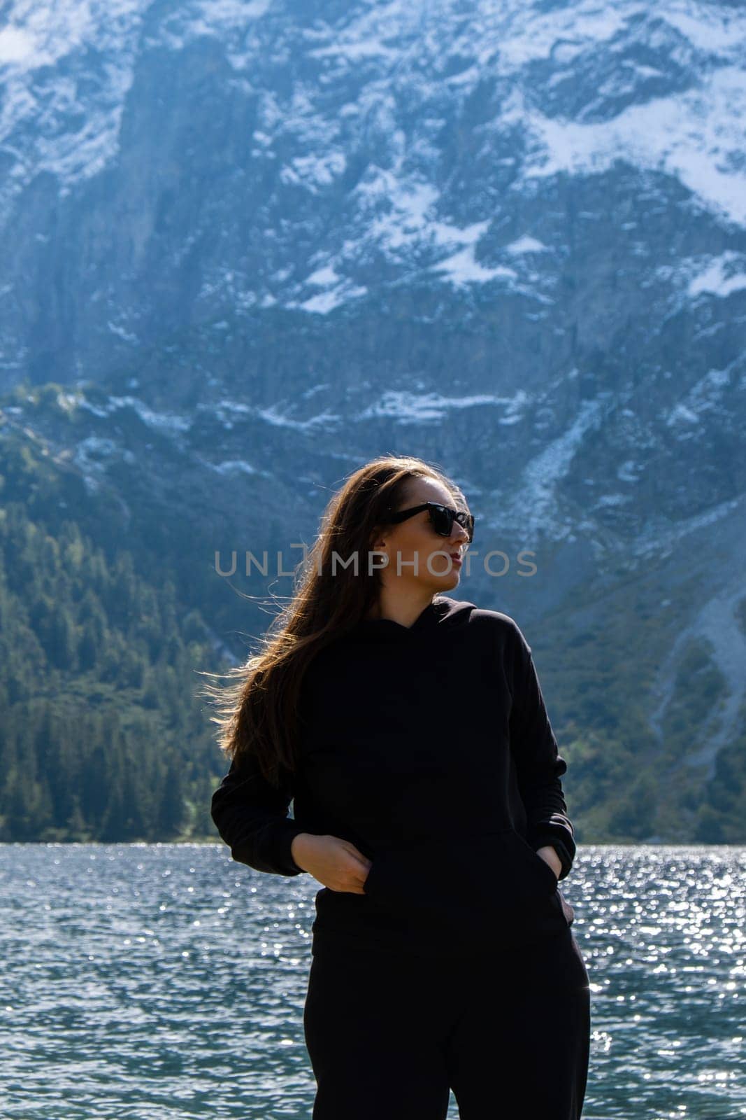 Young woman enjoying nature in Morskie Oko Snowy Mountain Hut in Polish Tatry mountains Zakopane Poland. Naturecore aesthetic beautiful green hills. Mental and physical wellbeing Travel outdoors tourist destination