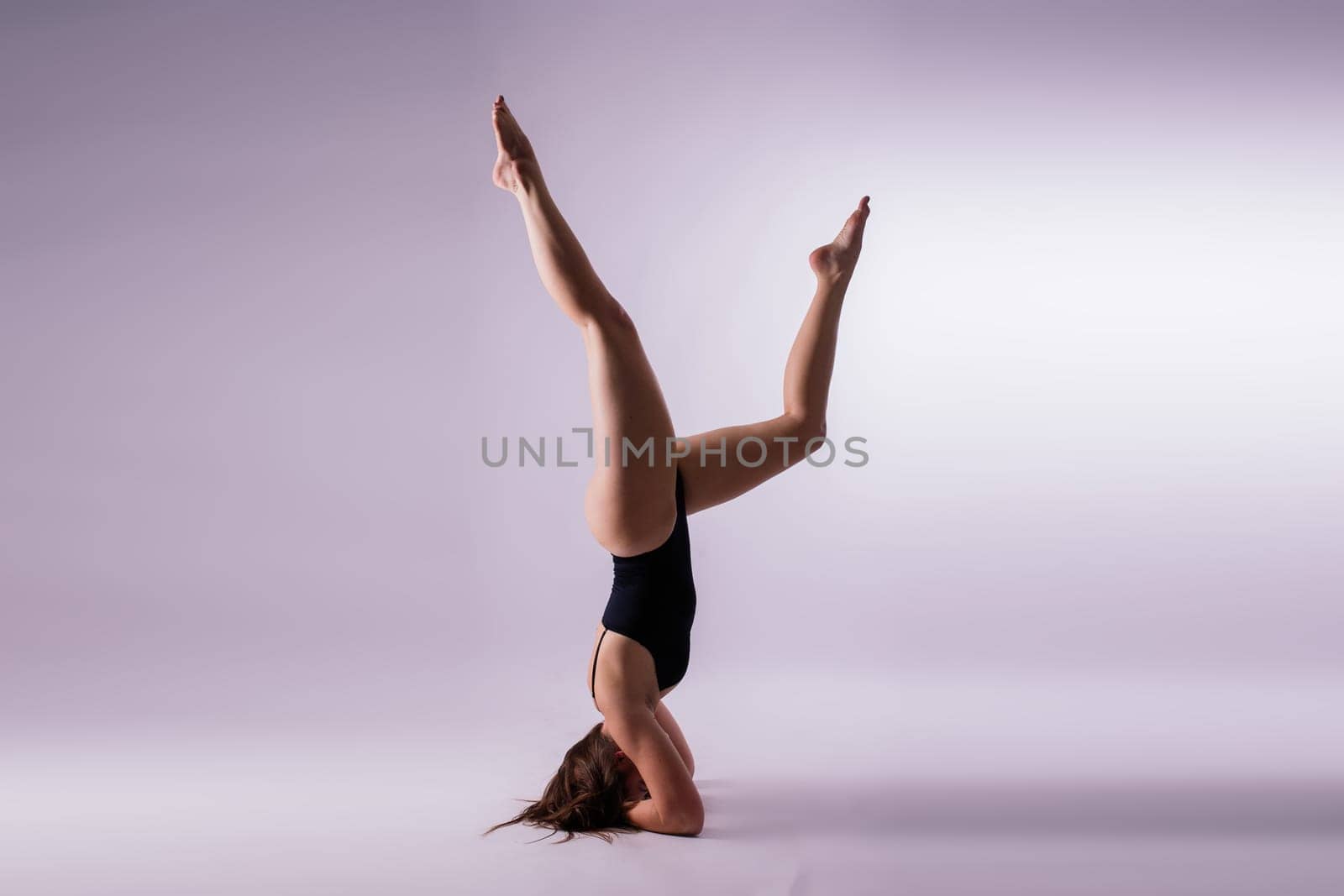 Athletic woman in swimsuit doing yoga, plank pose variation, beautiful female exercising studio by Zelenin