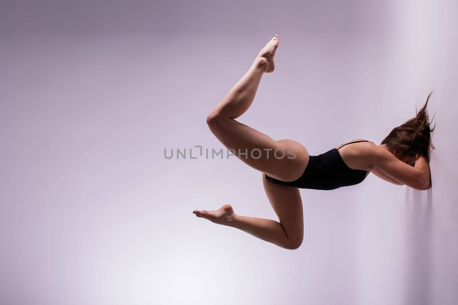 Athletic woman in swimsuit doing yoga, plank pose variation, beautiful female exercising studio by Zelenin