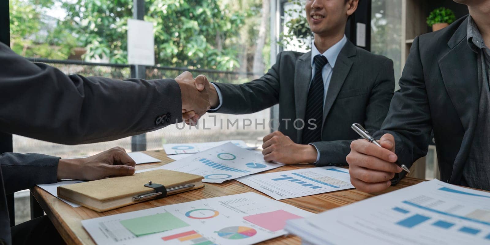 Young asia business shaking hands successful making a deal, business woman handshake. Business partnership meeting handshake concept by nateemee