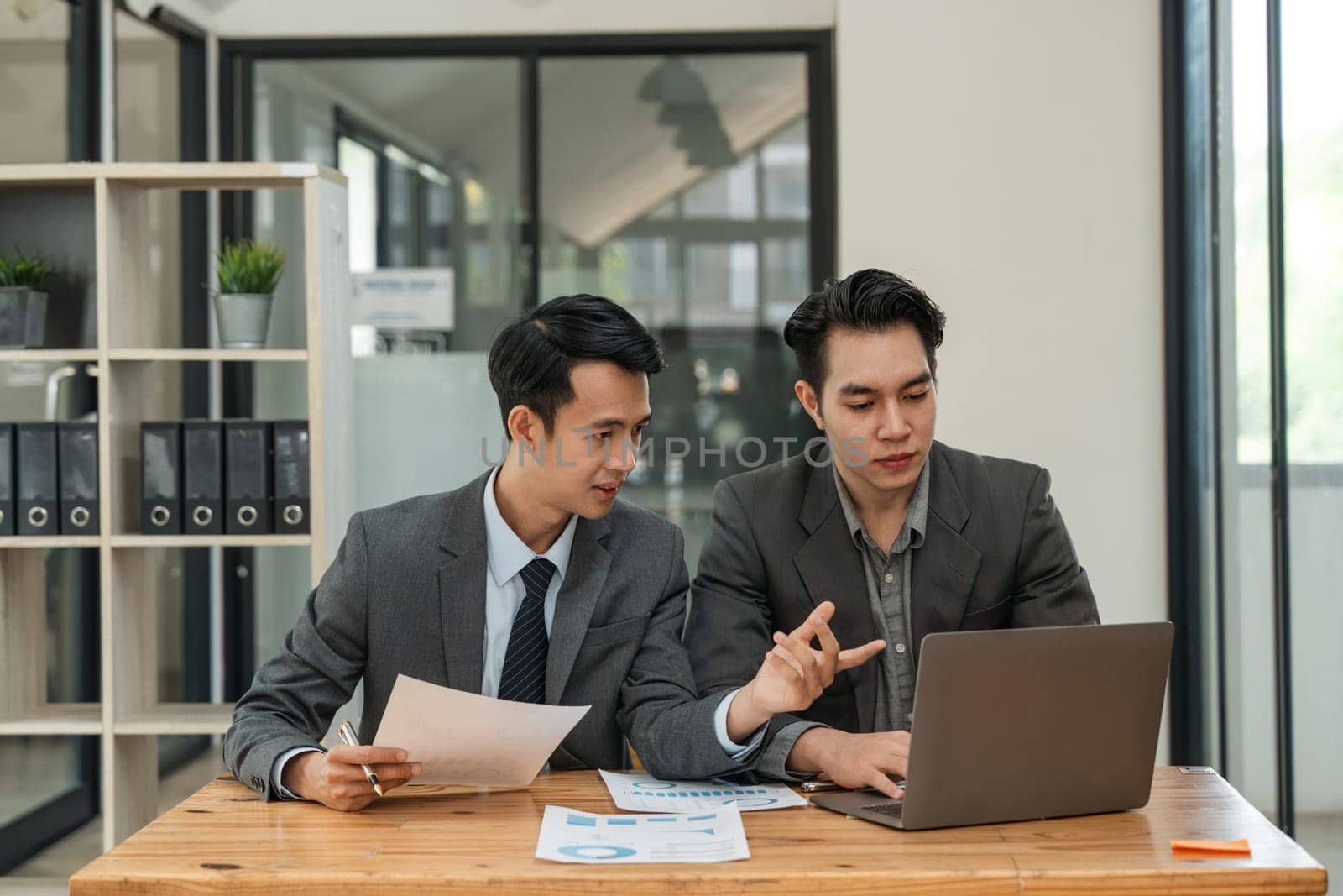 Asian business adviser meeting to analyze and discuss the situation on the financial report in the meeting room. Investment Consultant, Financial Consultant, Financial advisor and accounting concept.