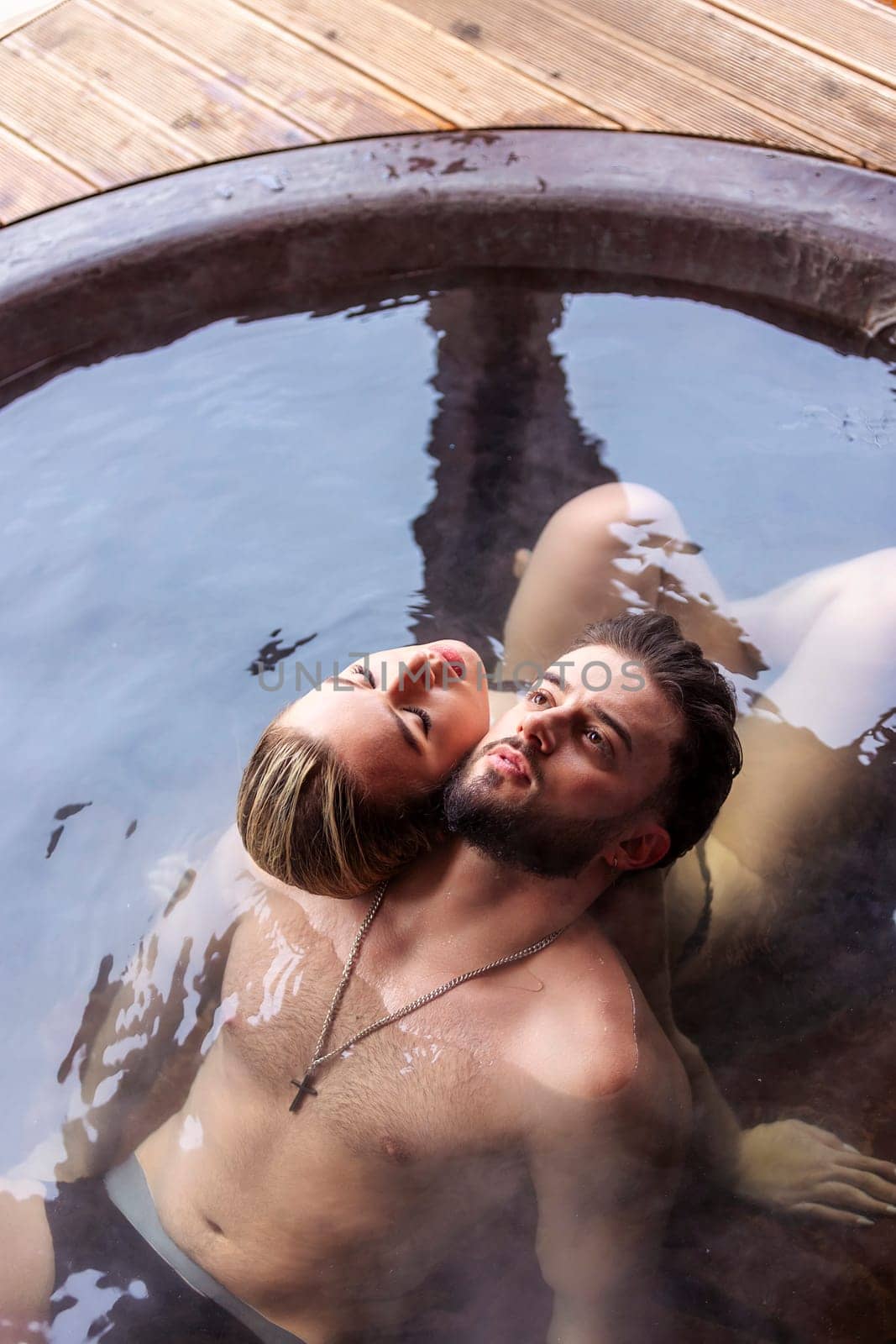 young couple hugging while sitting in a big vat by zokov