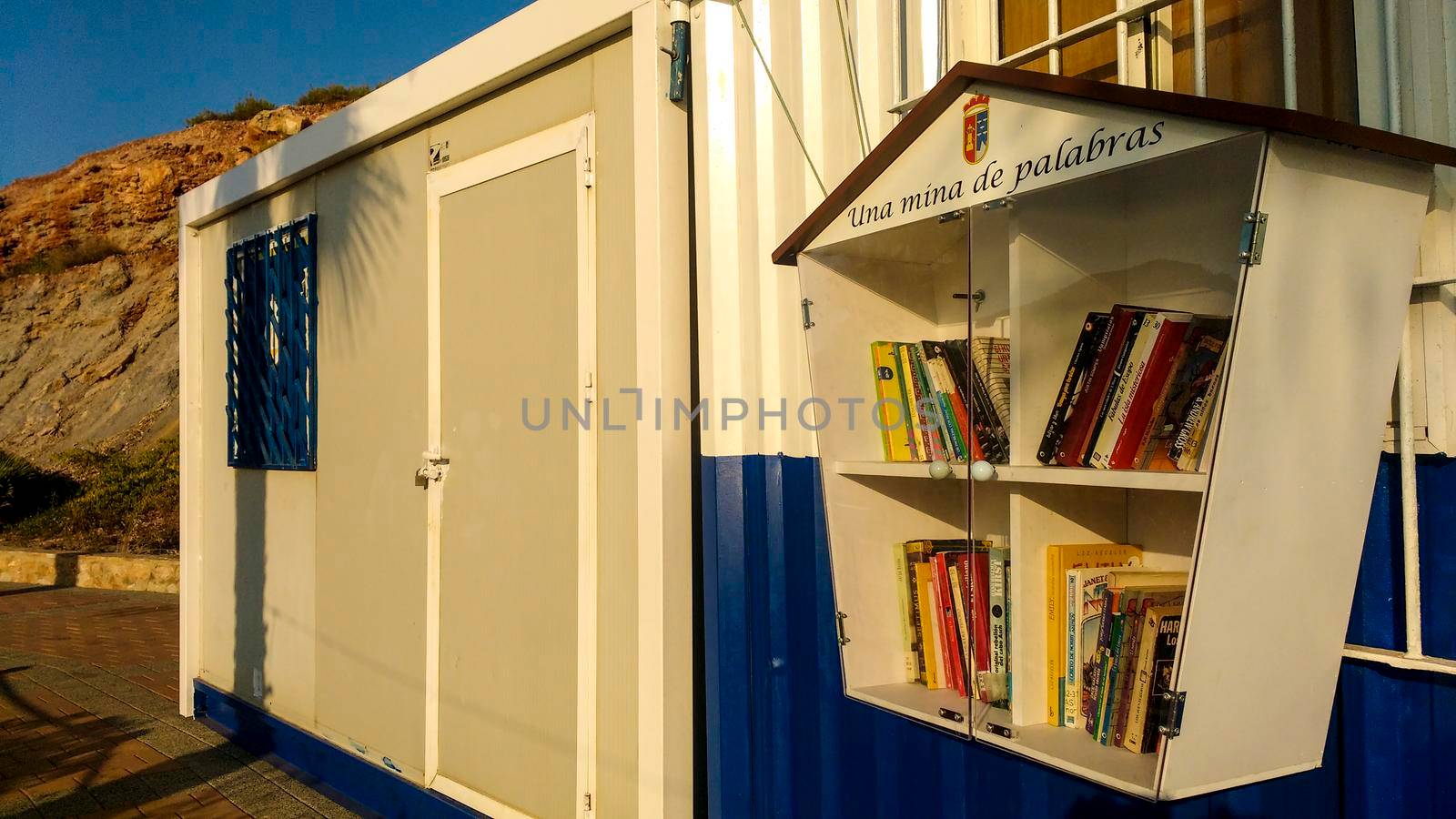 Portman, Cartagena, Spain- July 19, 2021: Street library available to the public on the beach of Portman village in summer