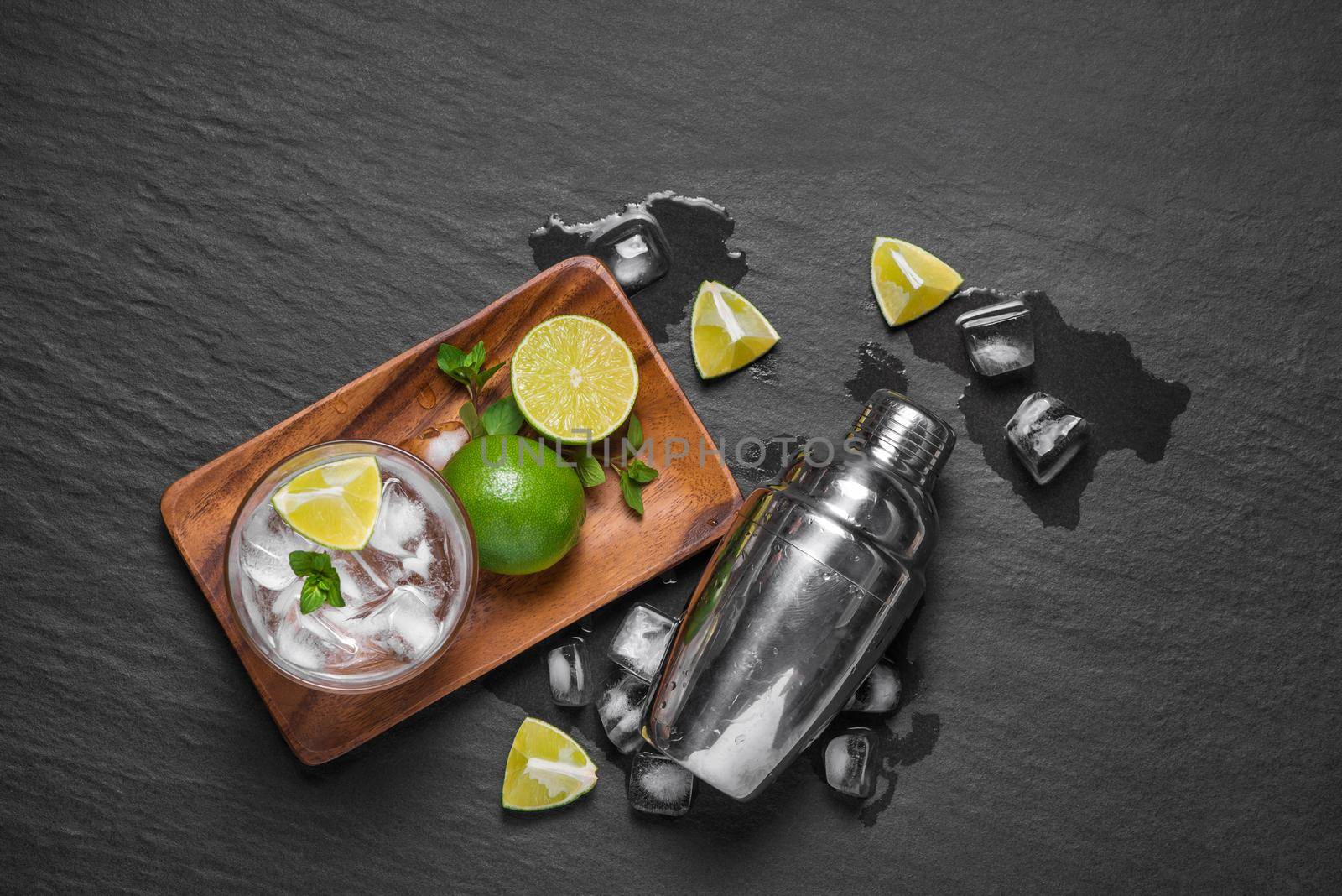 Mojito cocktail with lime and mint in glass on a grey stone background