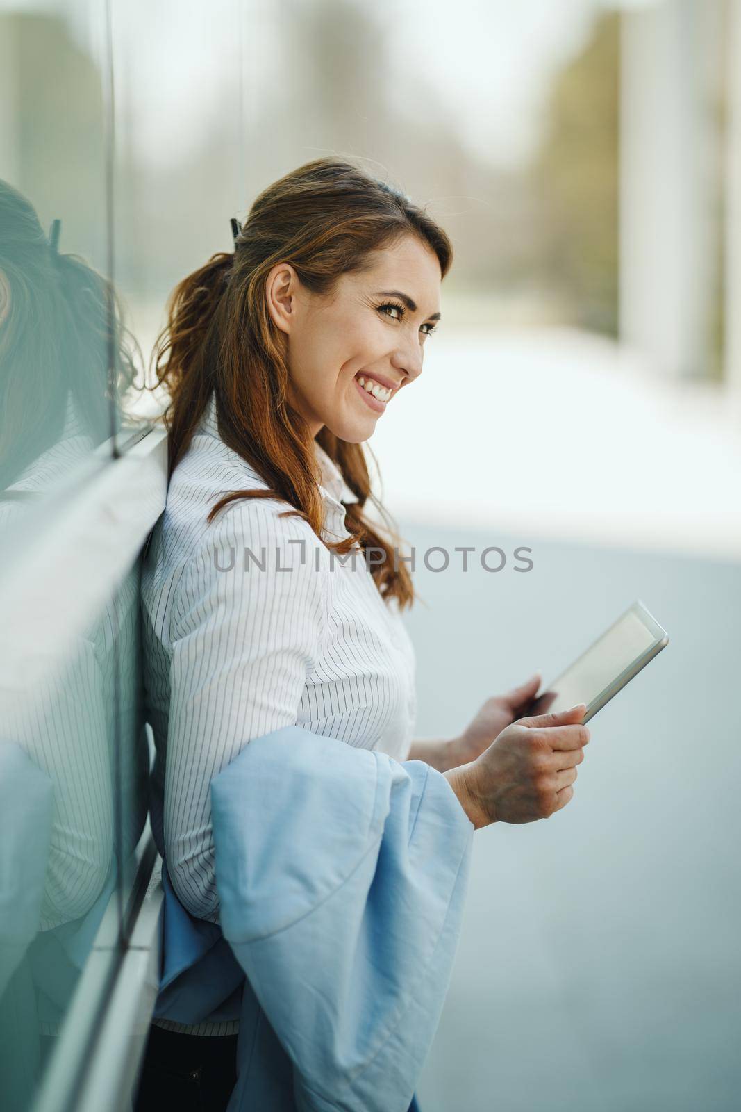 Shot of a young businesswoman using a digital tablet outside of an office building during break.