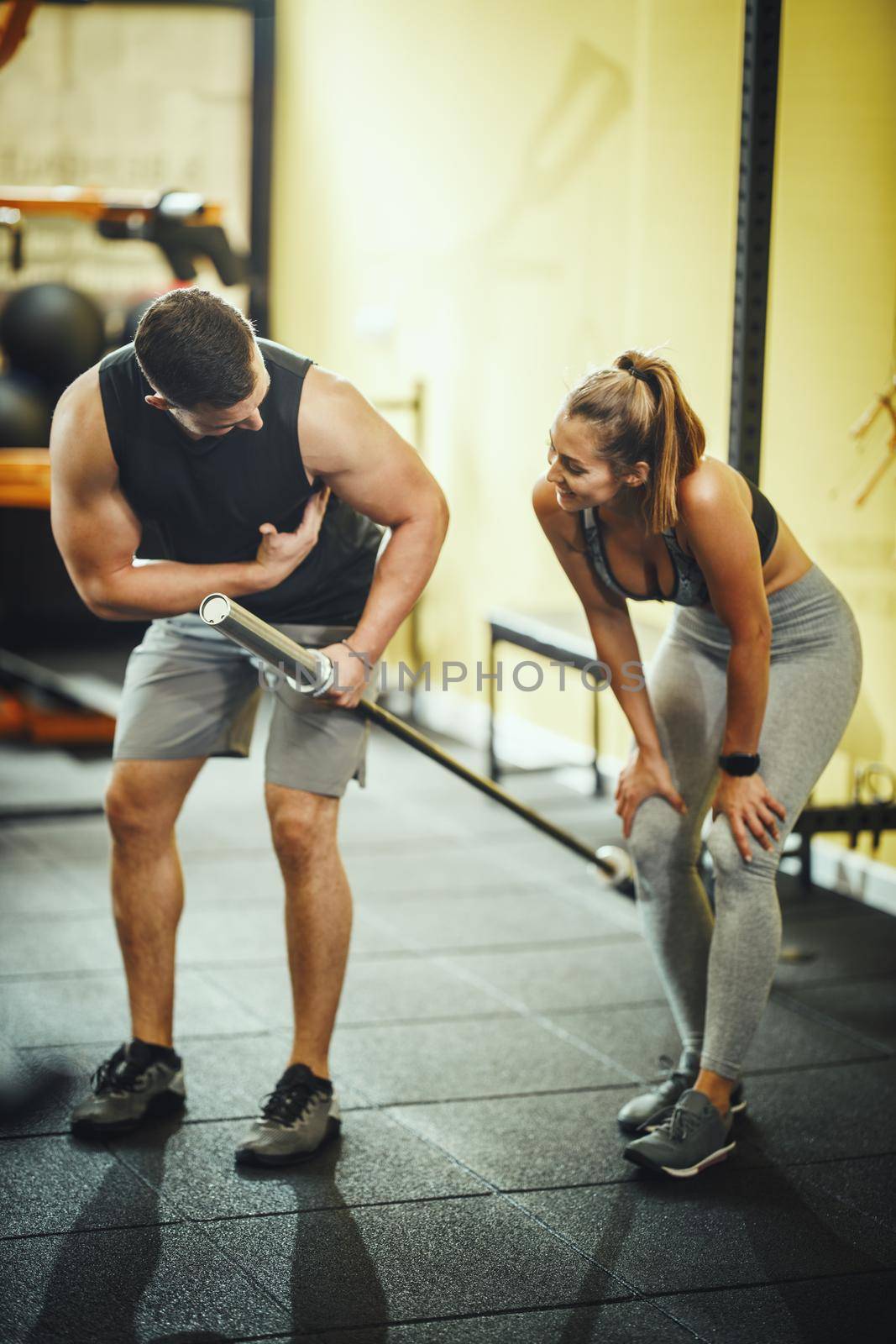 Shot of an attractive young woman working out with personal trainer at the gym.
