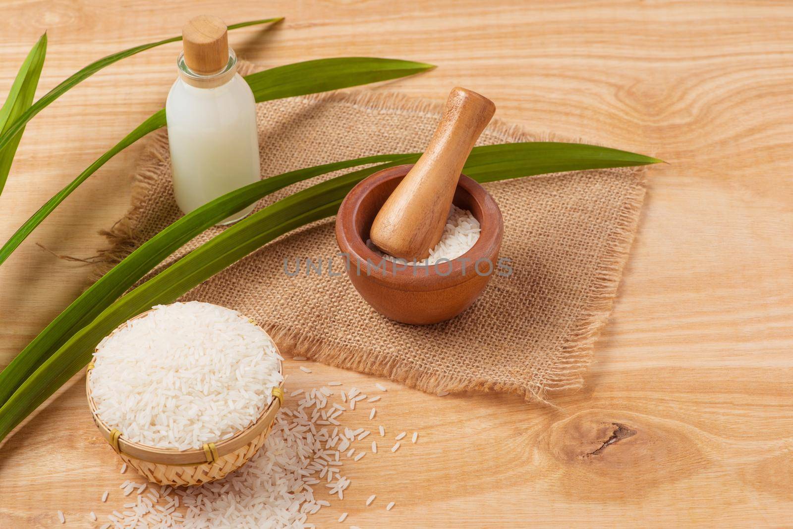 Rice flour in a wooden bowl, milk and rice on the old wooden background