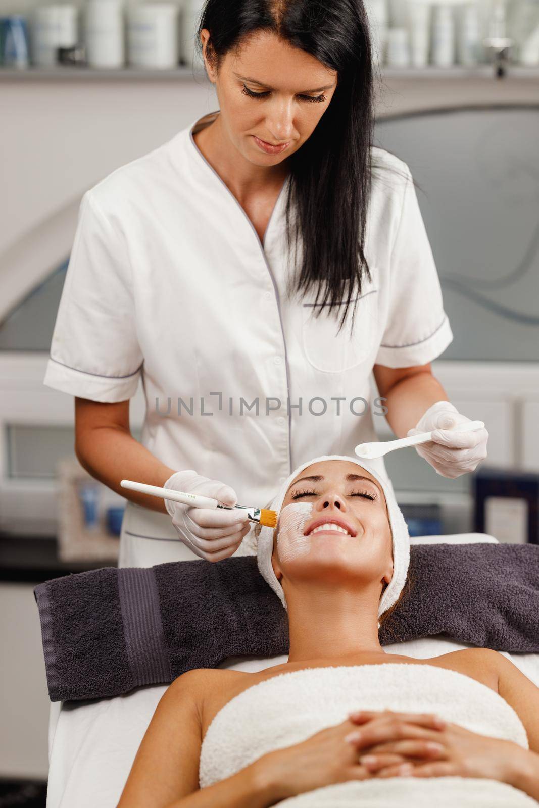 Shot of a beautiful young woman getting a facial mask treatment at the beauty salon.