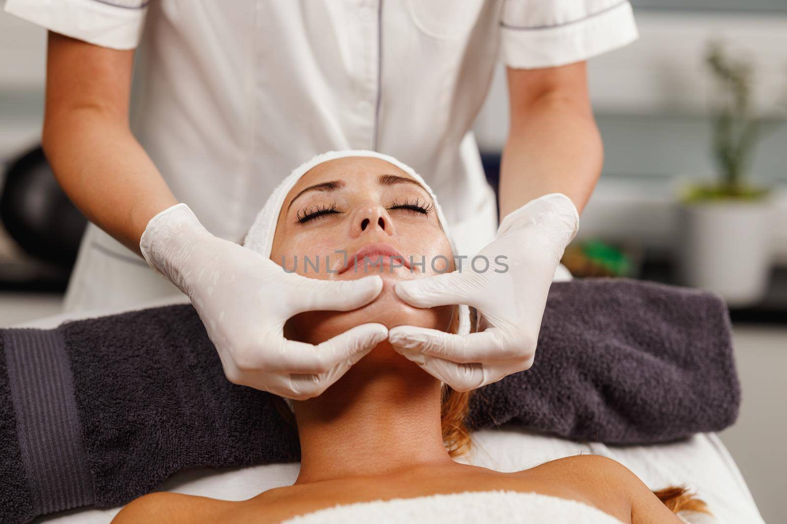 Shot of a beautiful young woman enjoying face massage at the beauty salon.