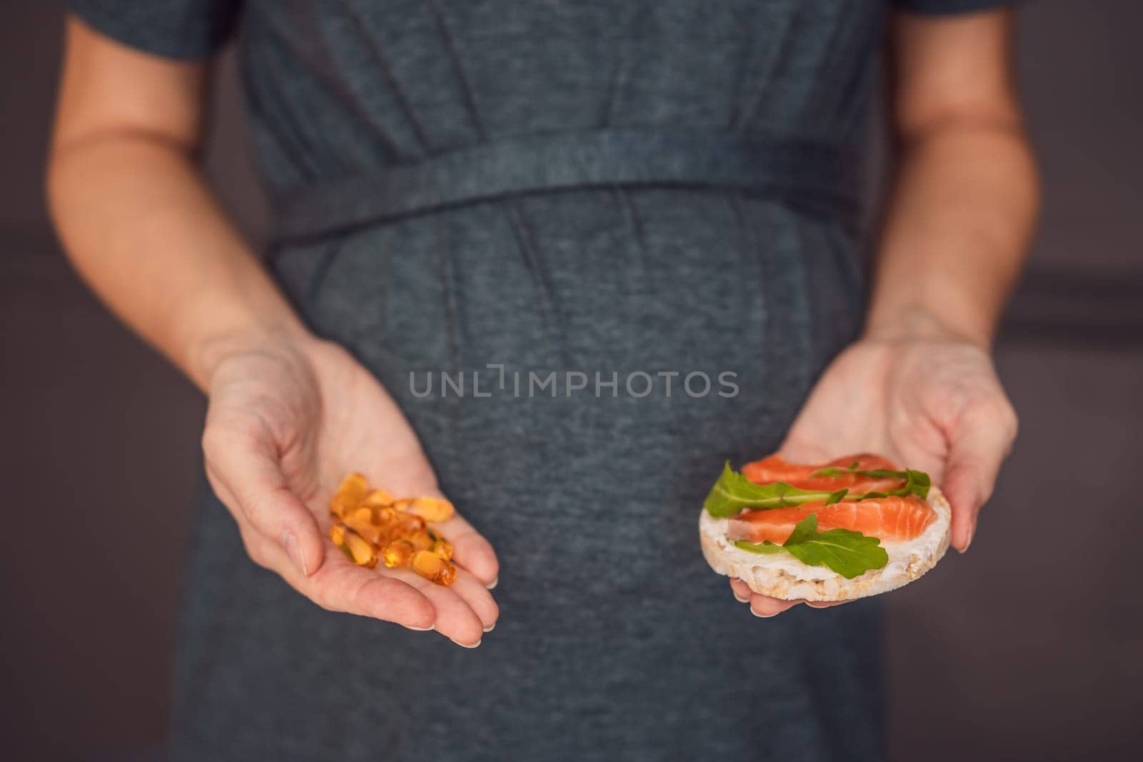A thoughtful pregnant woman over 40 considering whether to eat fish or opt for omega 3 capsules for a nourishing and healthy pregnancy.