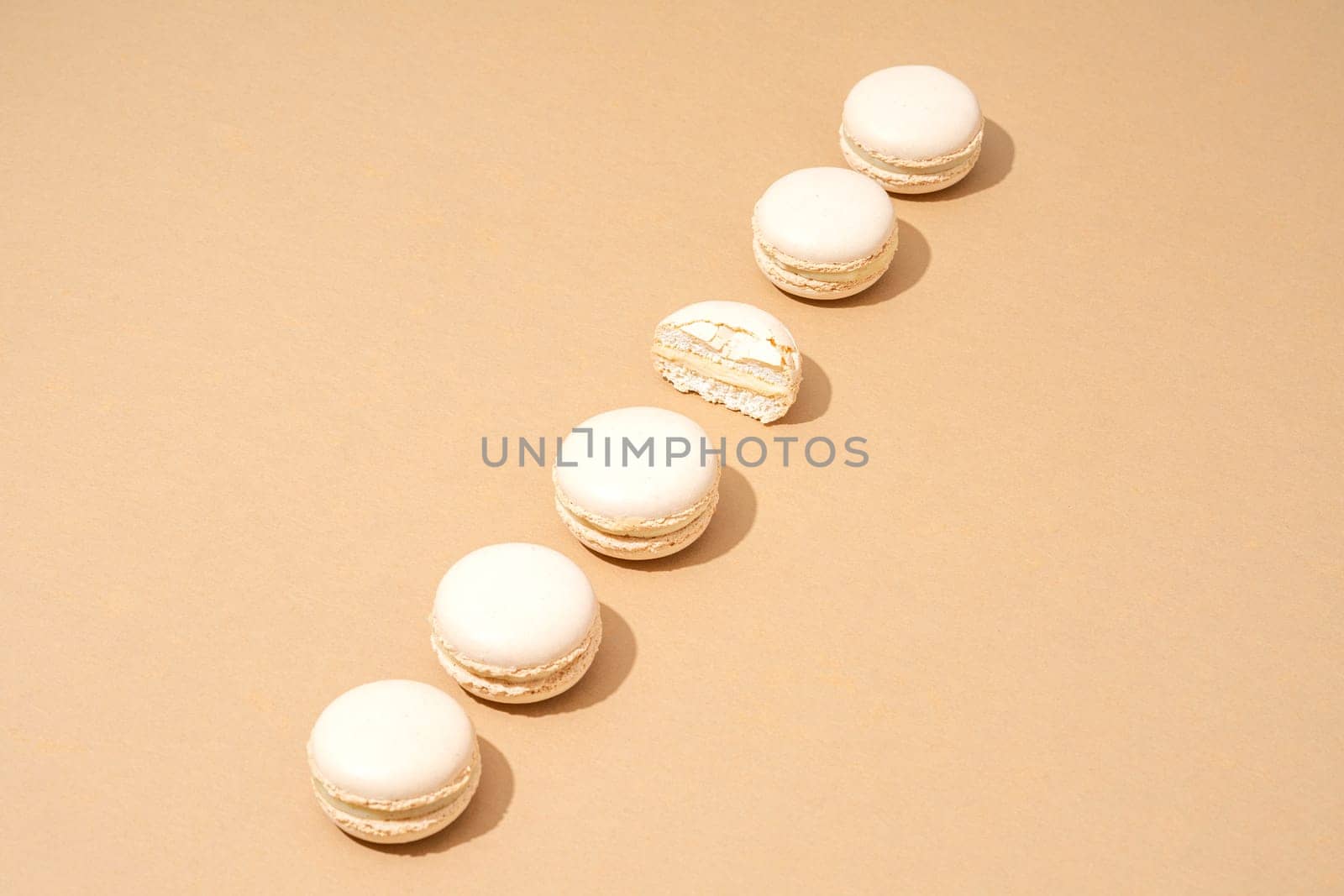 A still life image featuring six white macarons, arranged in a stack on top of each other by A_Karim