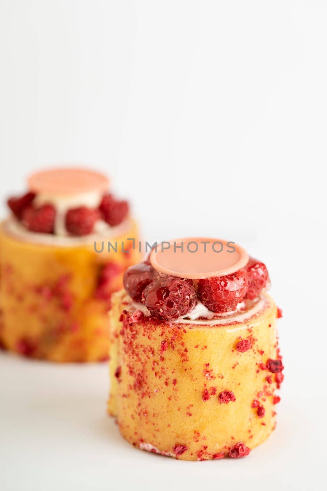 A delicious dessert of raspberry pudding topped with luscious cream and a sweet drizzle