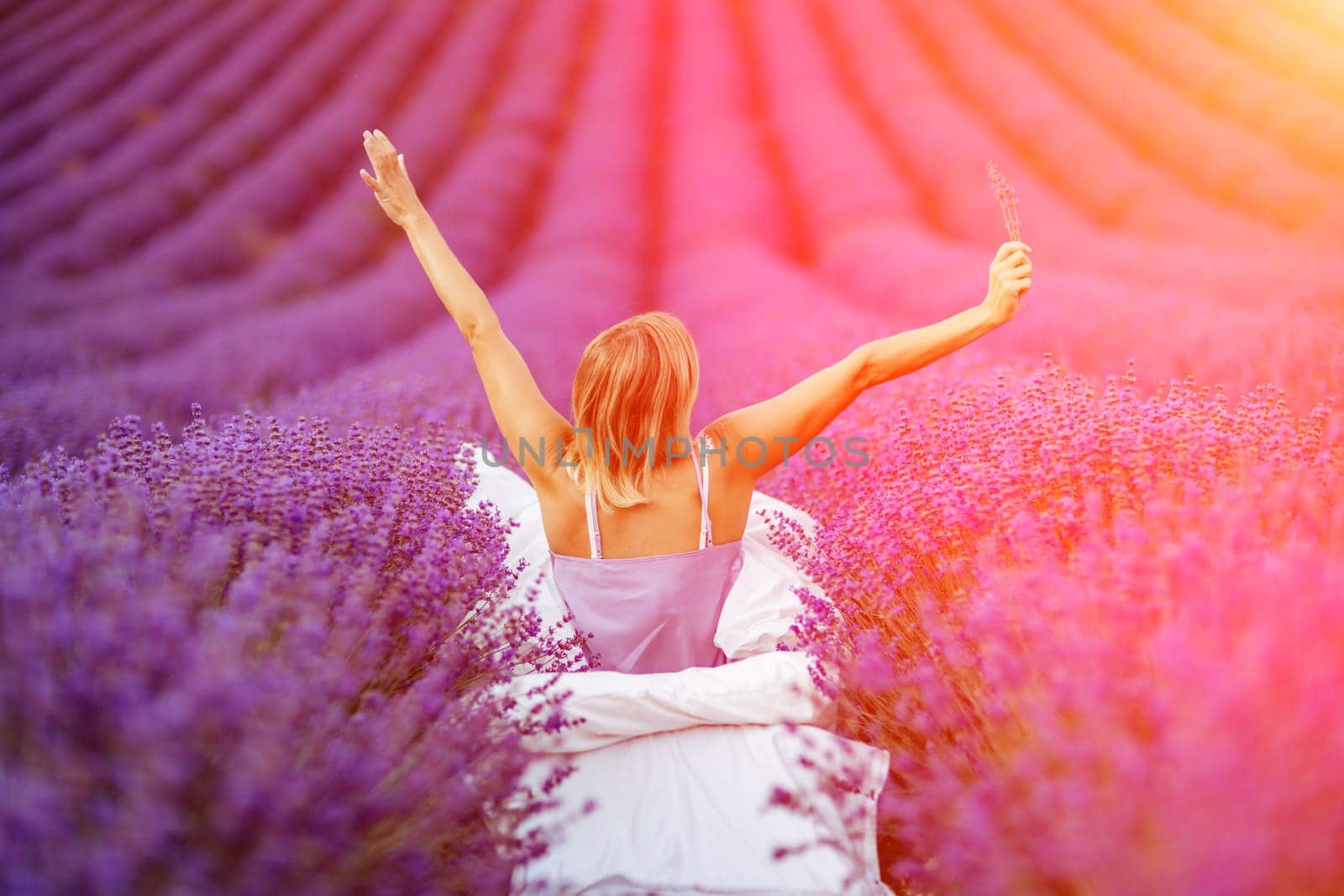 Woman lavender field. A middle-aged woman sits in a lavender field and enjoys aromatherapy. Aromatherapy concept, lavender oil, photo session in lavender by Matiunina