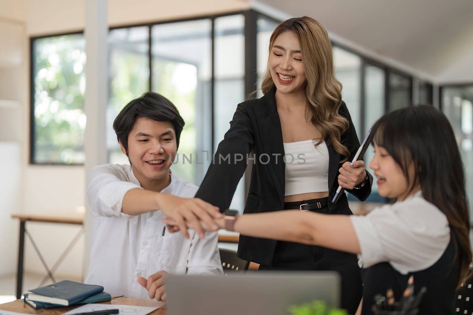 Business people stack touch arms palms together celebrating promotion reward, succeed common aim. Give high five symbol of unity, team building activity concept.
