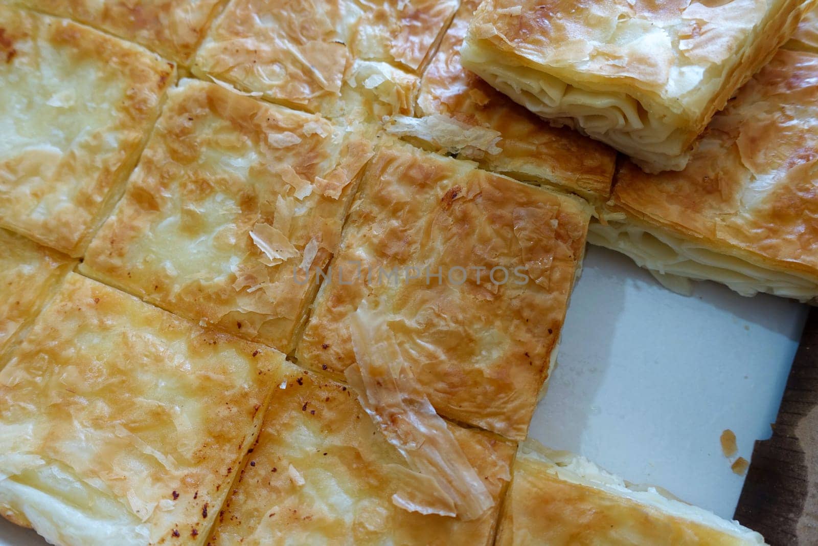 turkish style cheese pie, water borek turkish style close-up, cheese pie,a tray full of pastries, by nhatipoglu