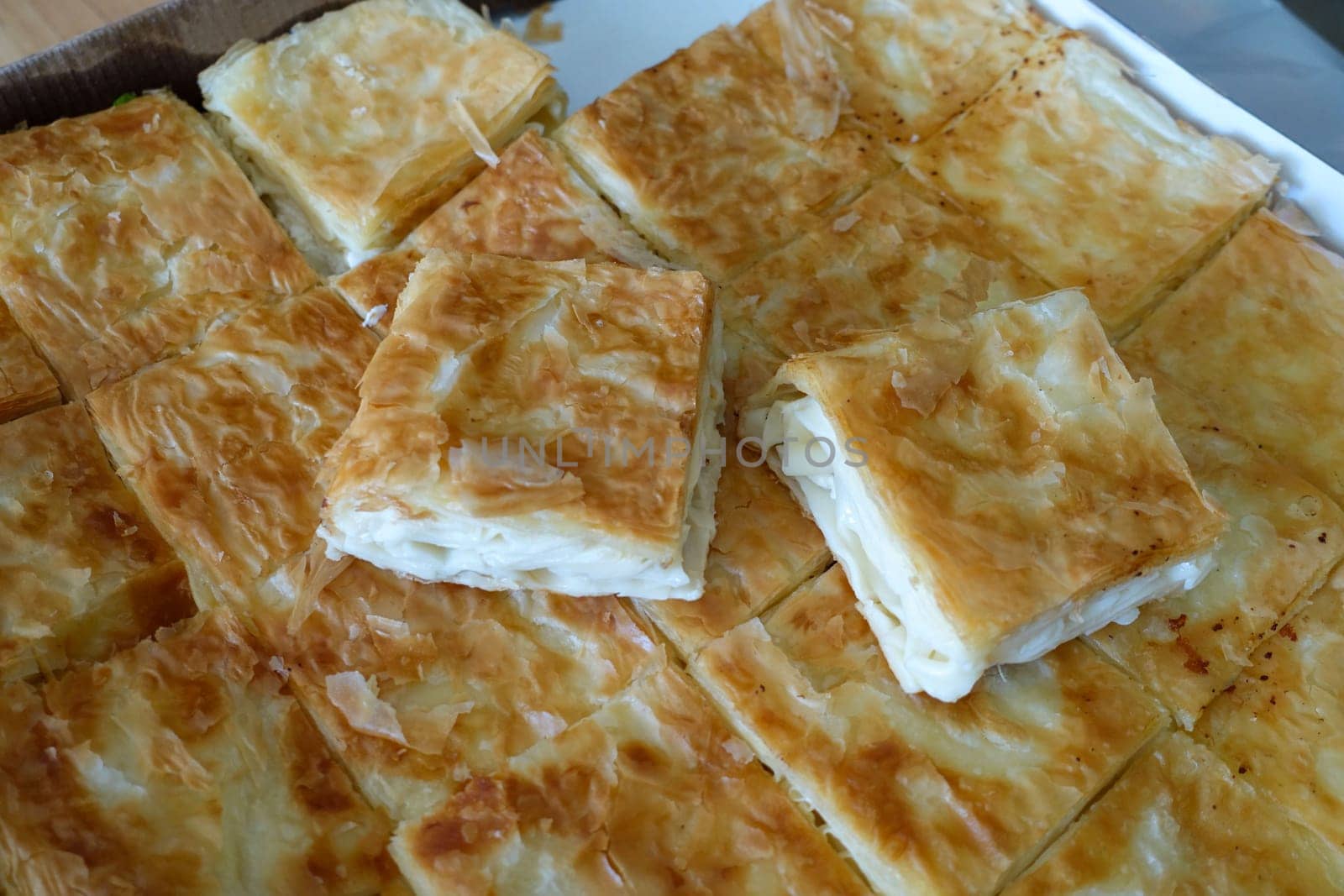 turkish style cheese pie, water borek turkish style close-up, cheese pie,a tray full of pastries, by nhatipoglu