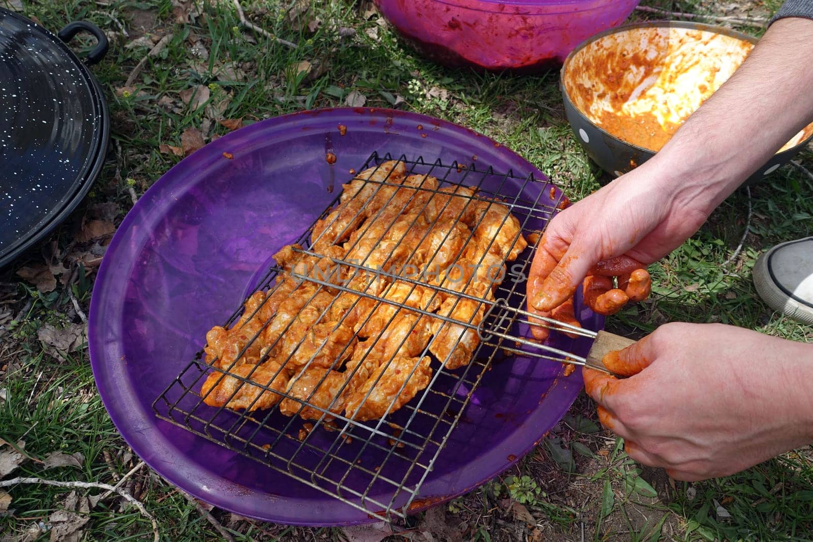 enjoying a barbecue at the picnic, arranging the chicken cutlet with sauce on the wire grill, grilled chicken cutlet,