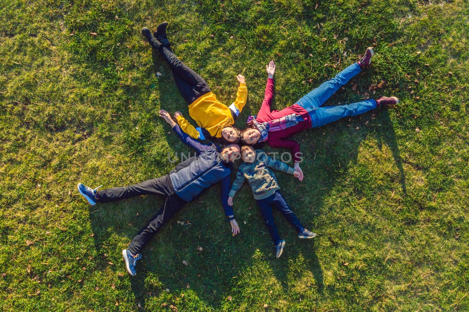 family top view. lying on the grass. sunny day. in green nature together. Aerial view Drone photography by galitskaya