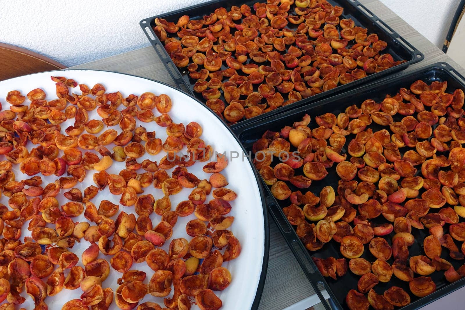 drying apricots in a metal tray on the balcony of the house, drying apricots in the sun, natural fruit drying process,