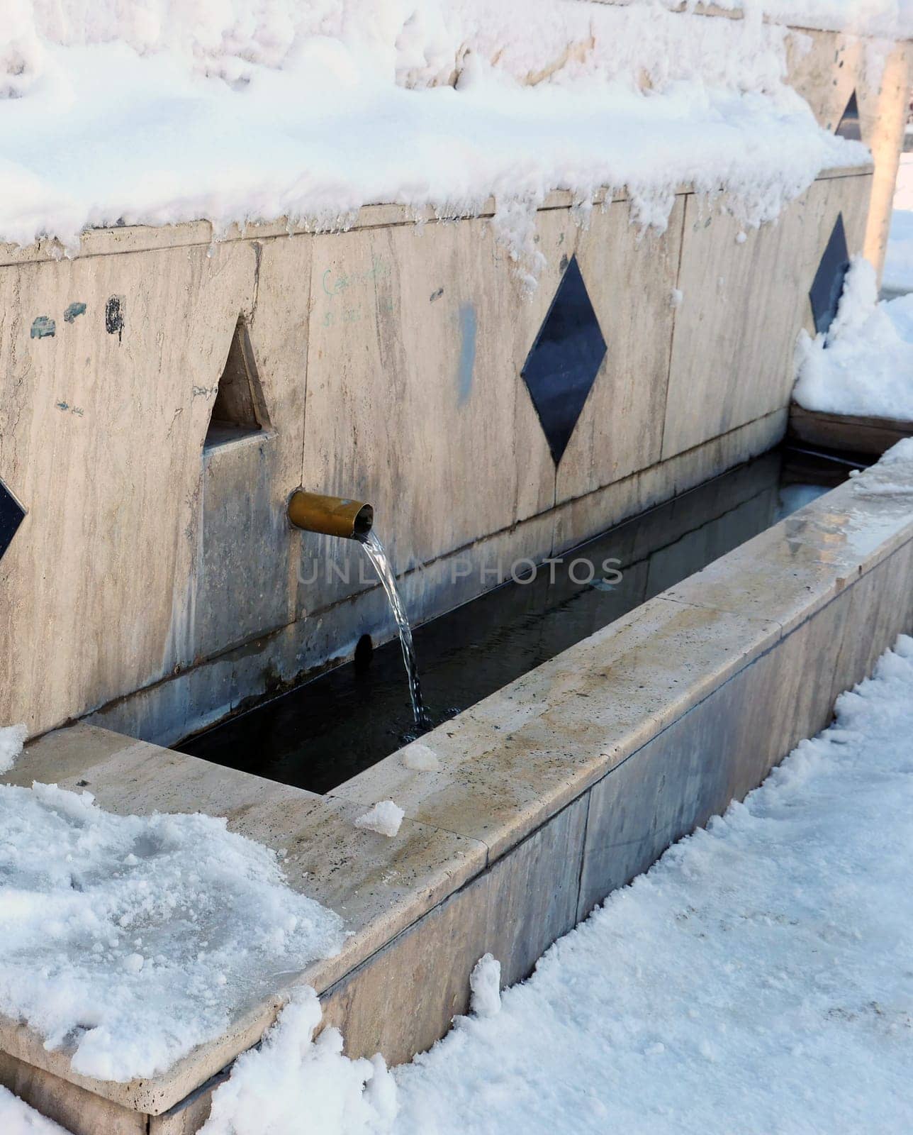 a fountain in the snow, a fountain that flows in winter