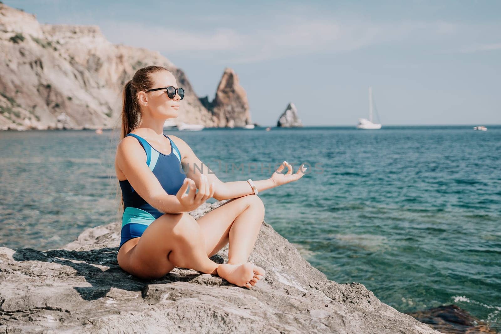 Woman sea yoga. Happy woman meditating in yoga pose on the beach, ocean and rock mountains. Motivation and inspirational fit and exercising. Healthy lifestyle outdoors in nature, fitness concept. by panophotograph