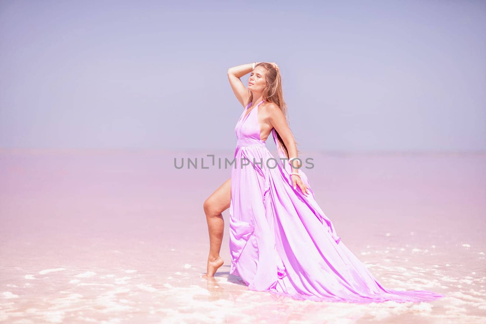 Woman pink salt lake. Against the backdrop of a pink salt lake, a woman in a long pink dress takes a leisurely stroll along the white, salty shore, capturing a wanderlust moment. by Matiunina