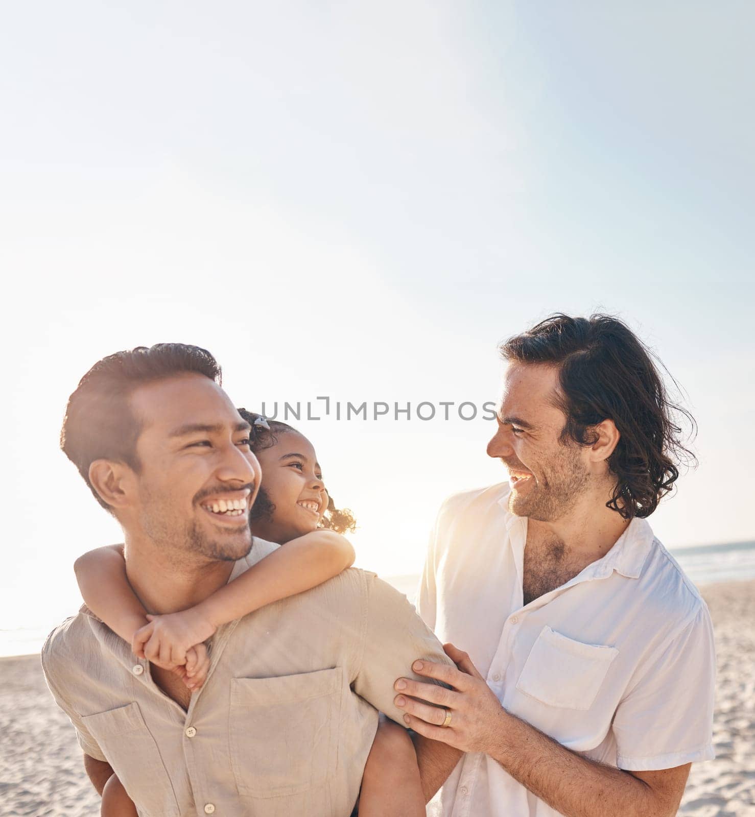 Funny, piggyback and lgbt family at beach for love, care and a vacation in summer. Smile, interracial and gay parents laughing with child at sea during a holiday for bonding, travel or mockup space.