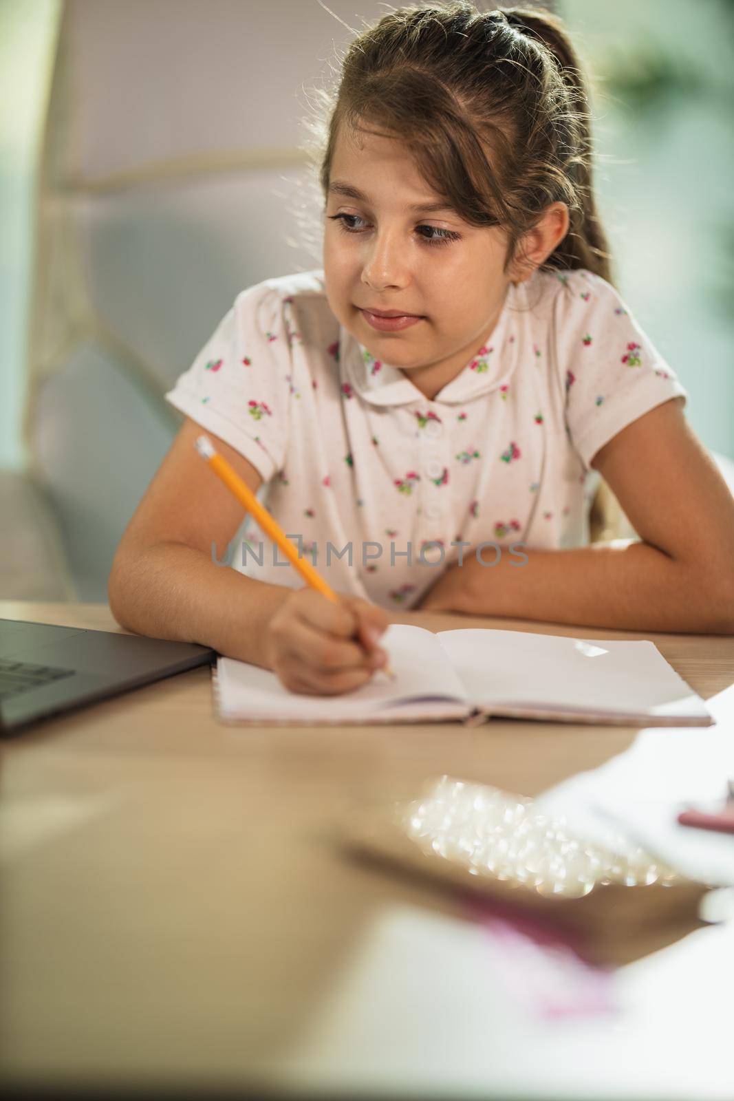 Shot of a diligent little girl doing a homework assignment at home during COVID-19 pandemic.