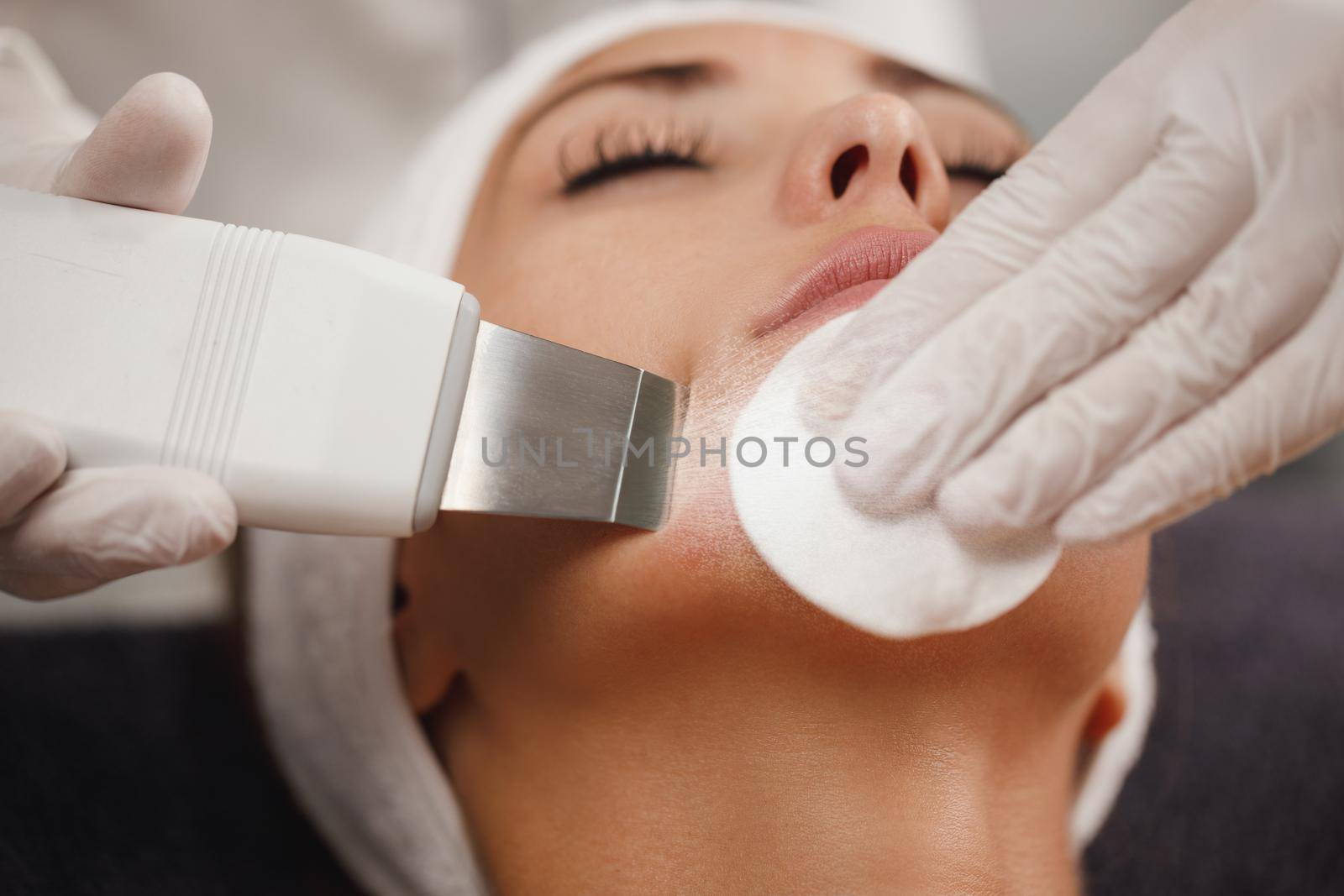 Shot of a beautiful young woman on a ultrasonic facial treatment at the beauty salon.
