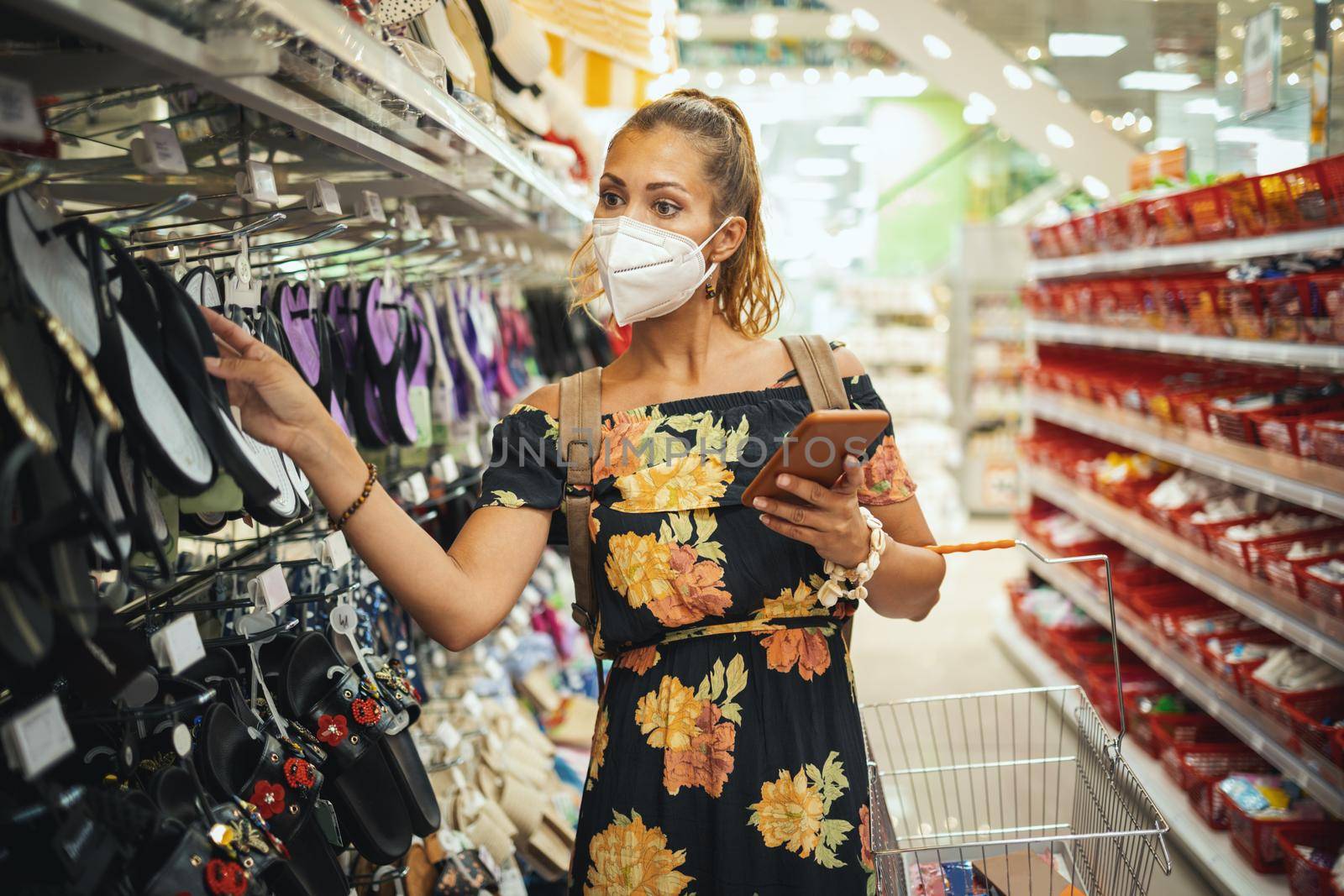 Shot of a young woman is wearing N95 protective mask while buying in supermarket during Covid-19 pandemic.