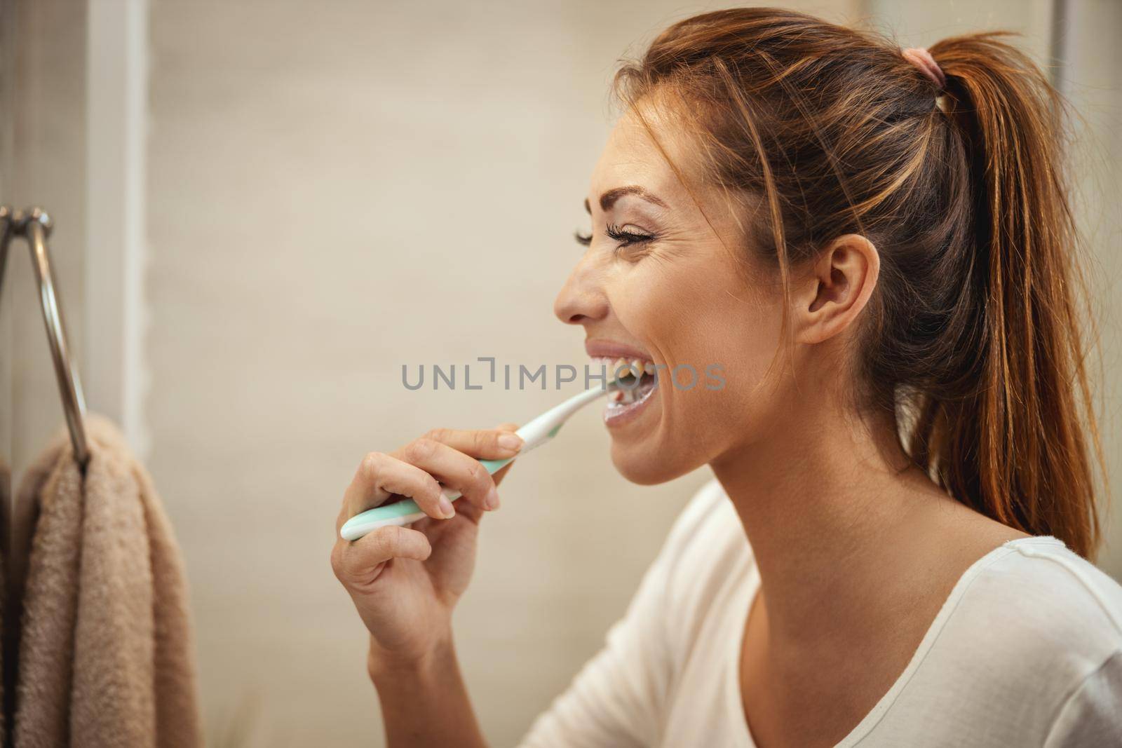 Shot of an attractive young woman who brush her teeth in the bathroom at home.