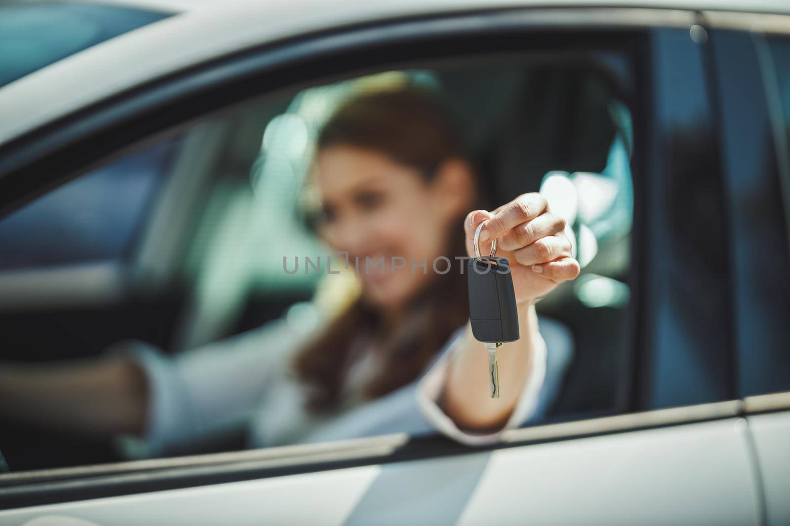 Cropped shot of a woman holding the keys to her new car. Selective focus. Focus on key.