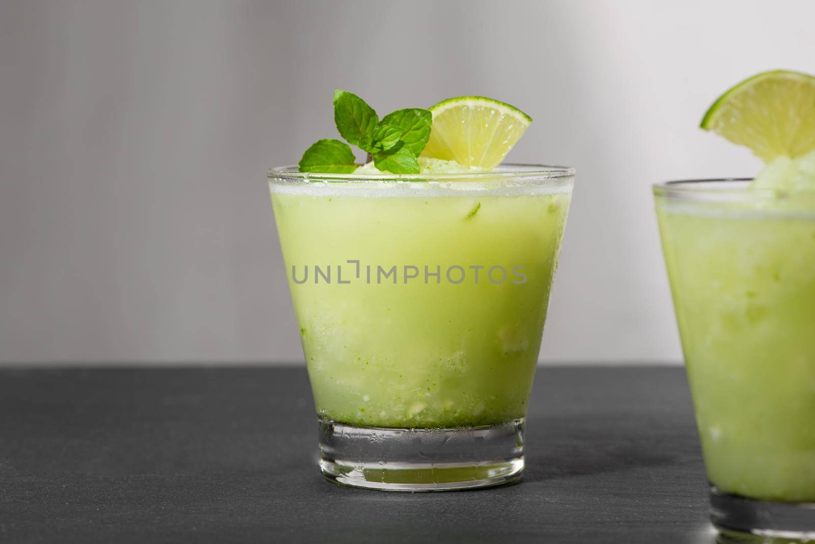 Cocktail juice with lime, mint and ice. Bar drink accessories on black table background. by makidotvn