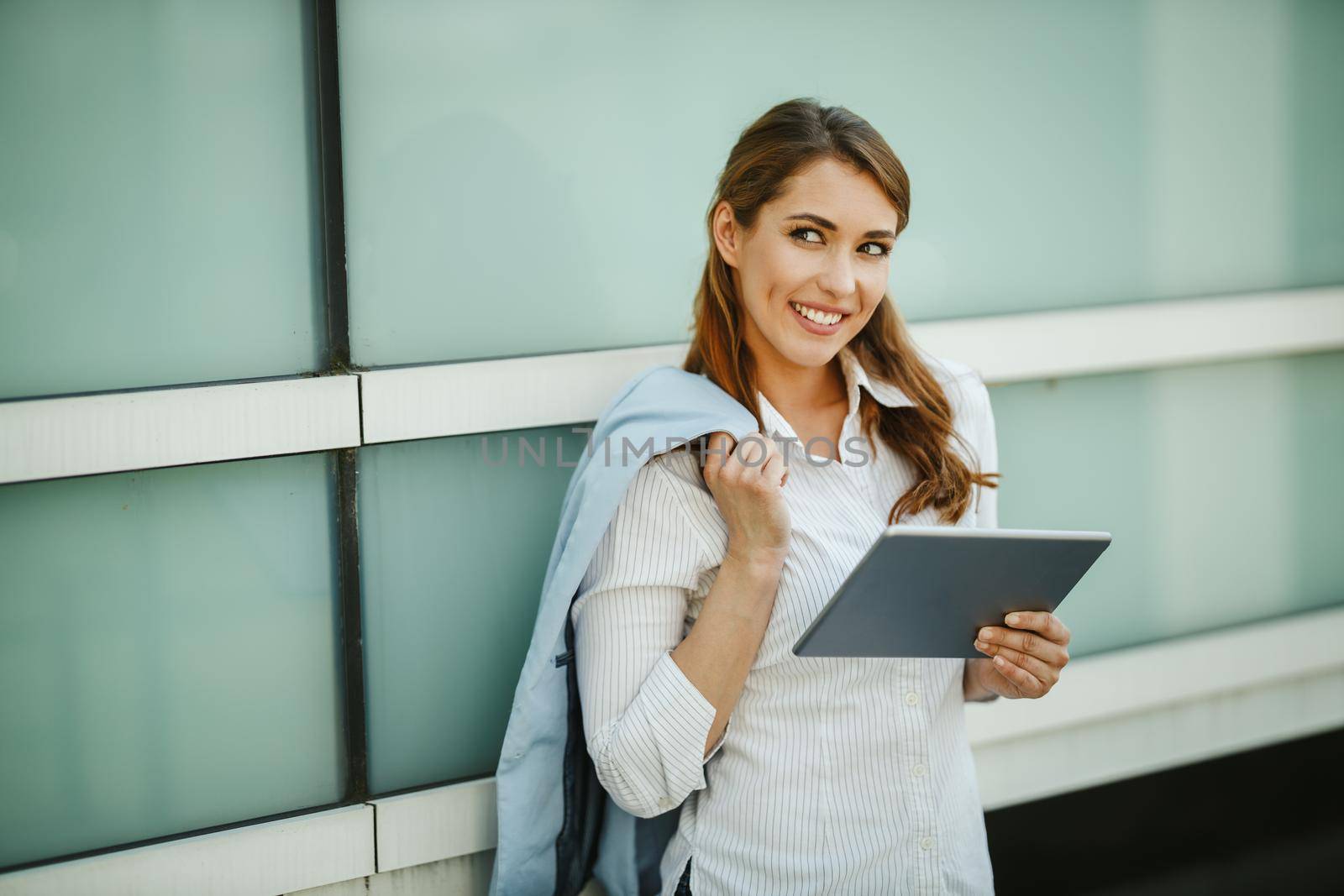 Shot of a young businesswoman using a digital tablet outside of an office building during break.