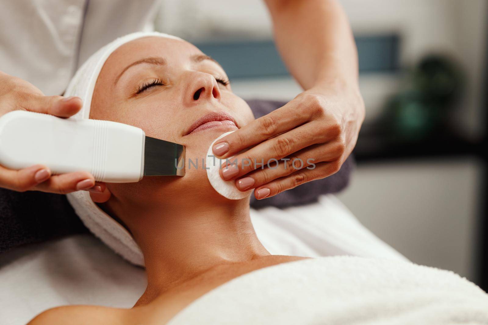 Shot of a beautiful mature woman on a ultrasonic facial treatment at the beauty salon.