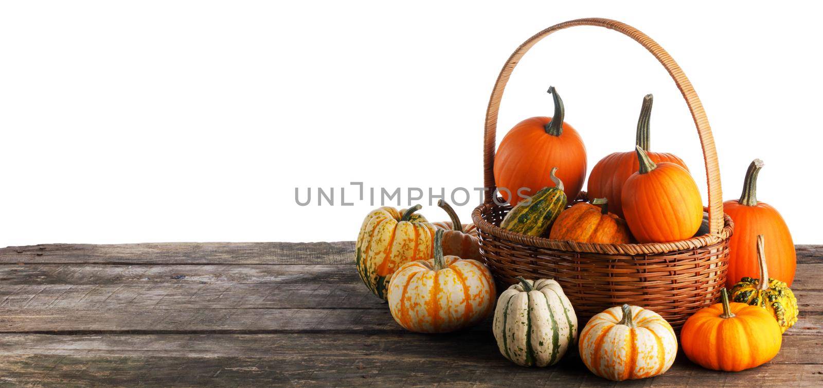 Basket with pumpkins on wooden table by Yellowj