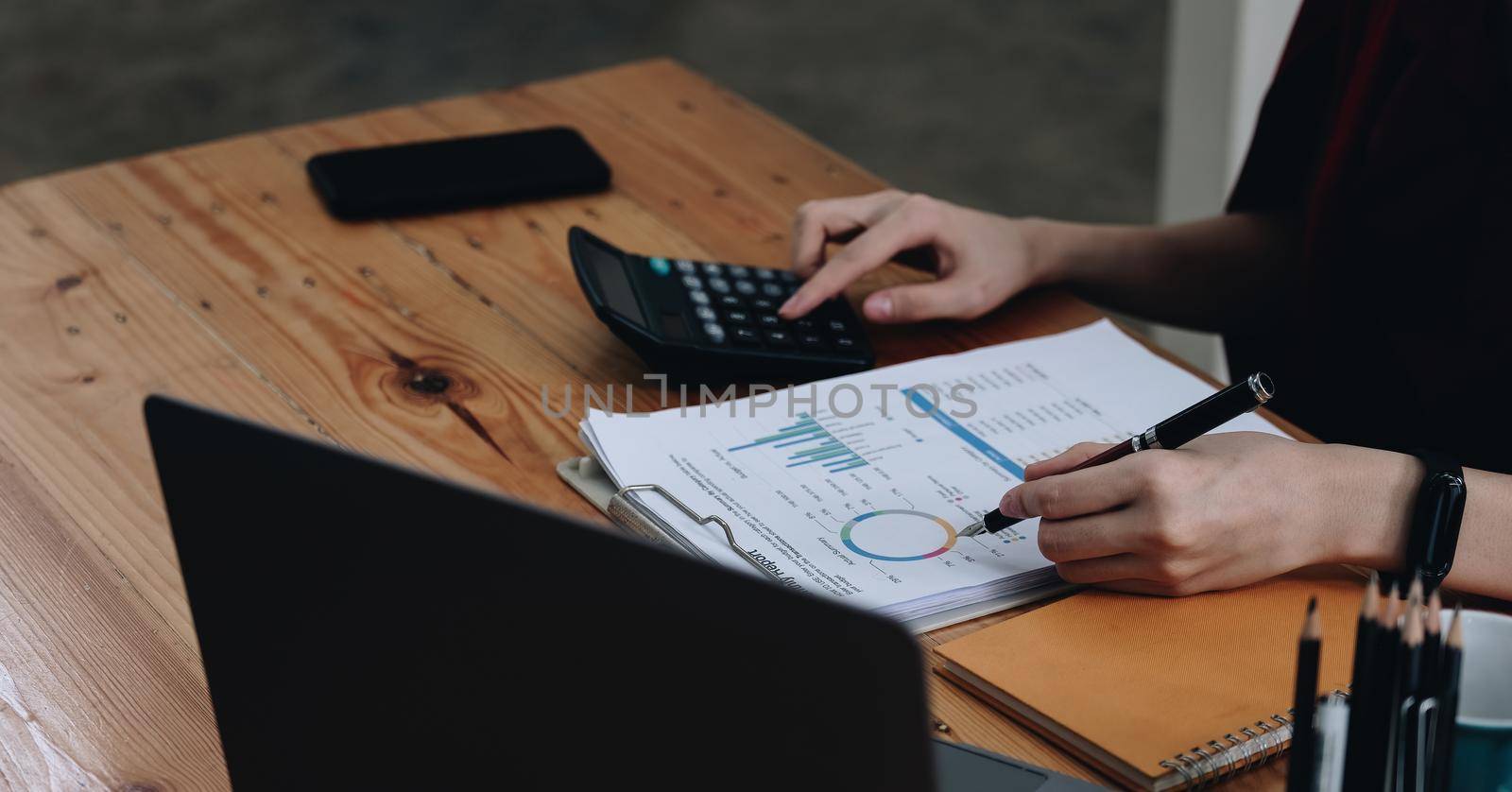 Business woman entrepreneur using a calculator to calculating financial expense at office. financial accounting concept by nateemee