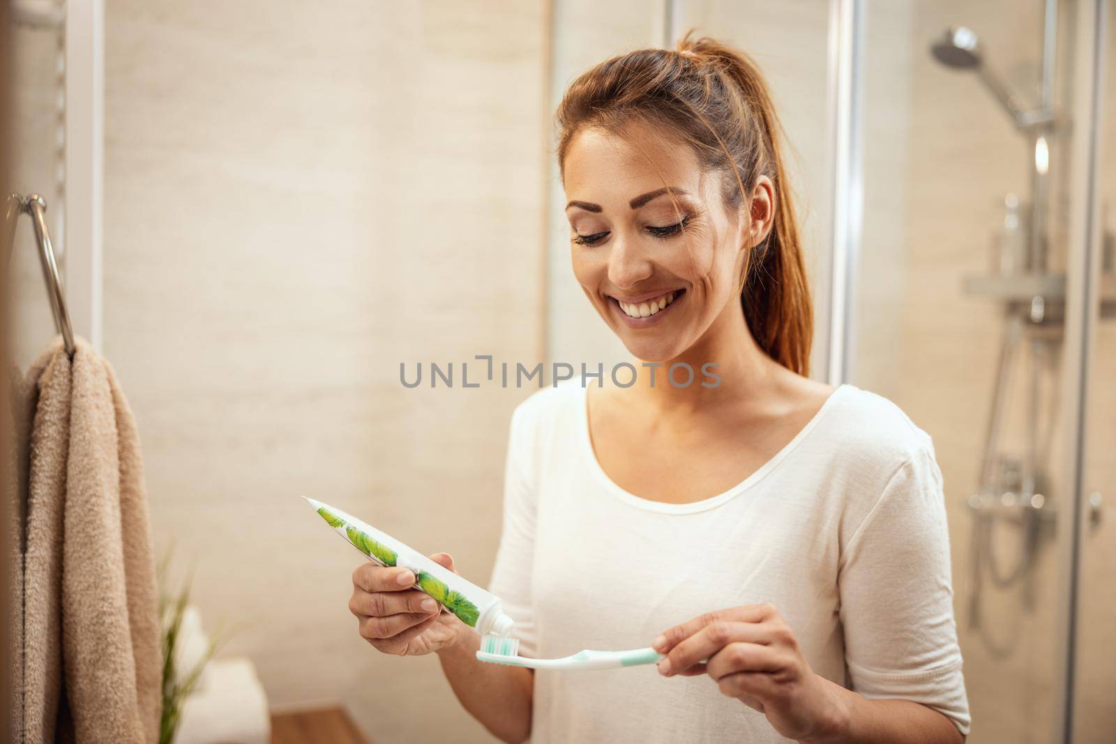 Shot of an attractive young woman about to brush her teeth in the bathroom at home.