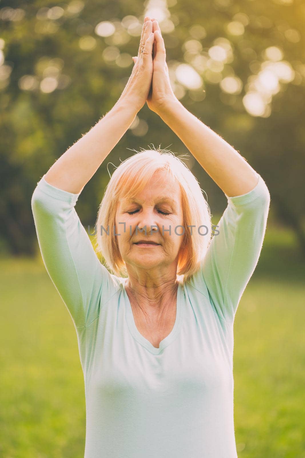 Senior woman enjoys meditating in the nature