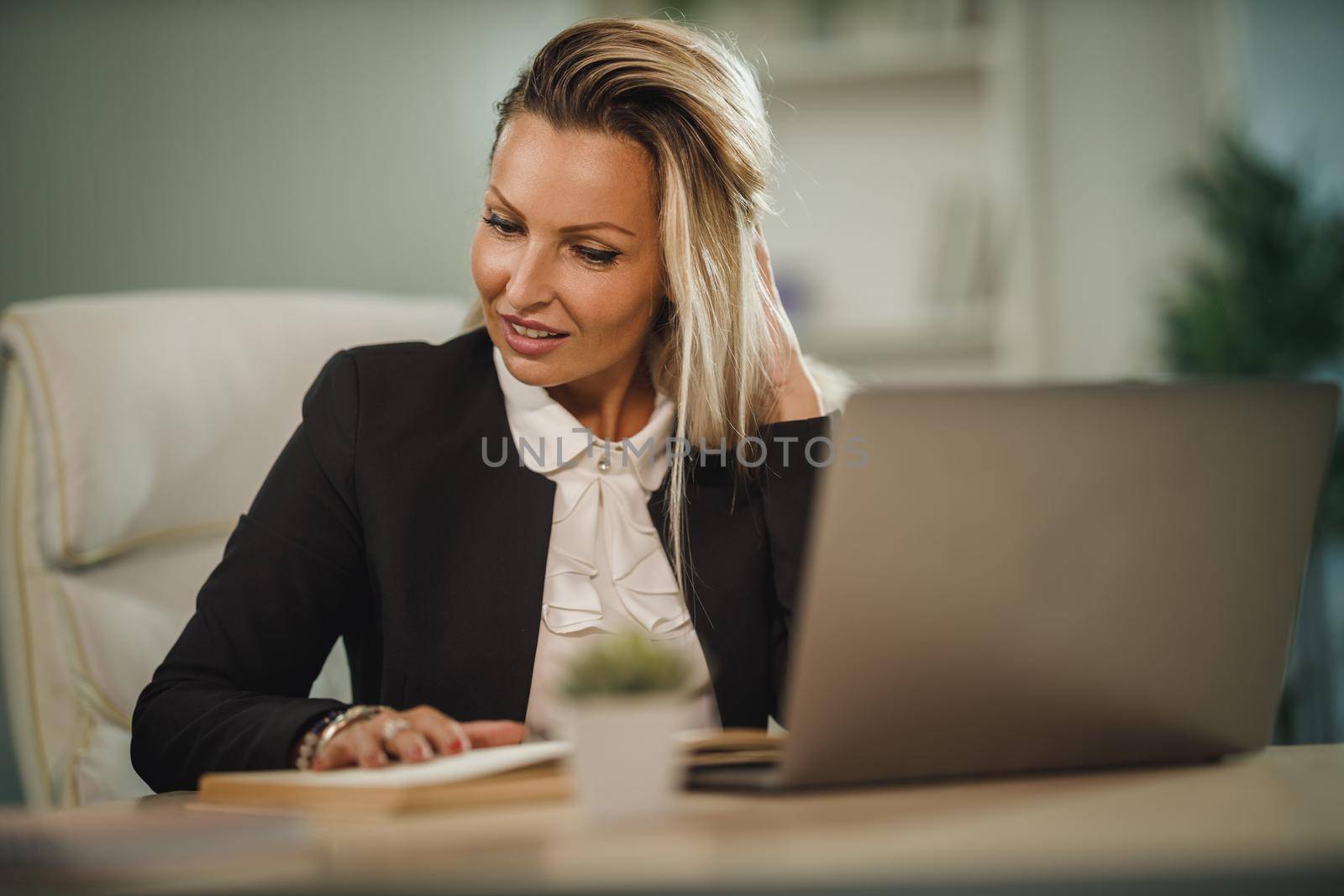 Portrait of a confident attractive business woman sitting at her office desk and working during COVID-19 pandemic.