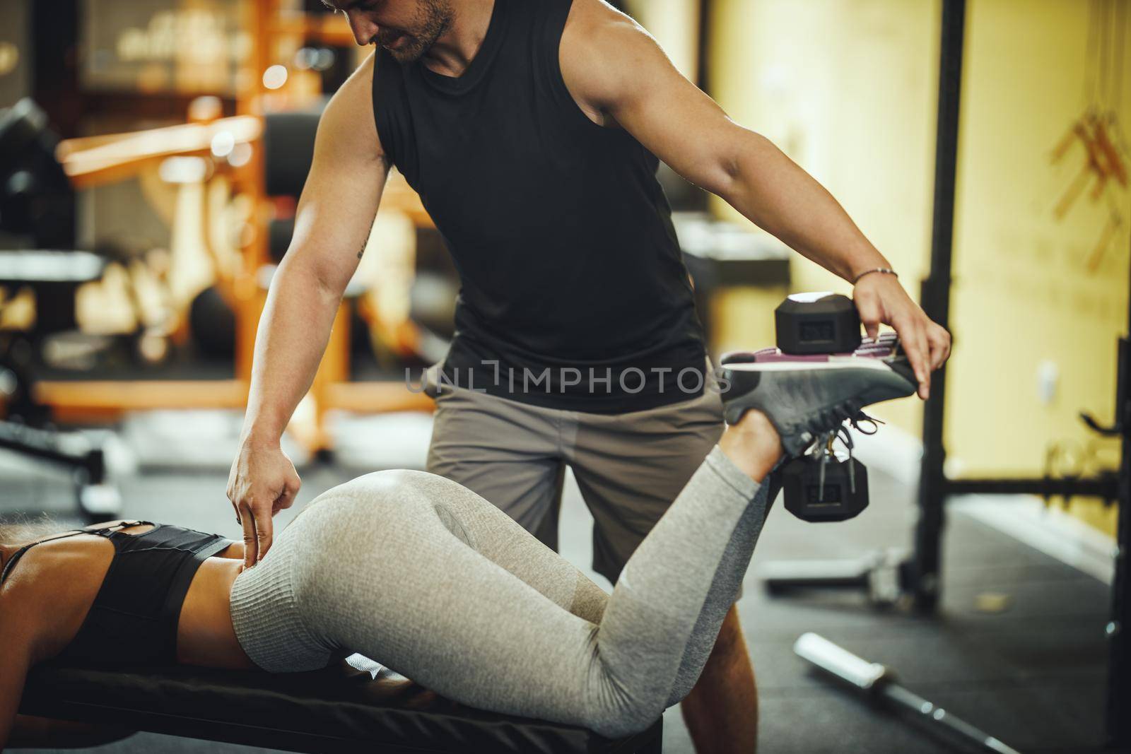 Cropped shot of an attractive young woman working out with personal trainer at the gym.