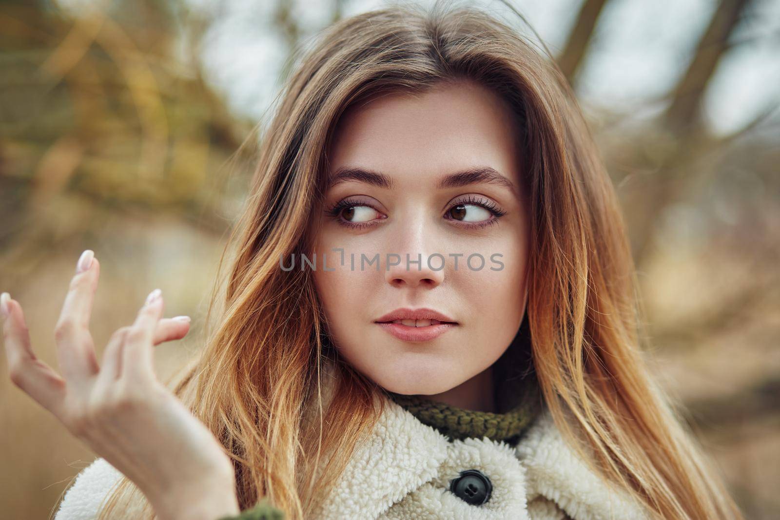 Beautiful woman hair fluttering in the wind. Smiling woman laughing on the street cheerfully. Lovely young lady feeling happy